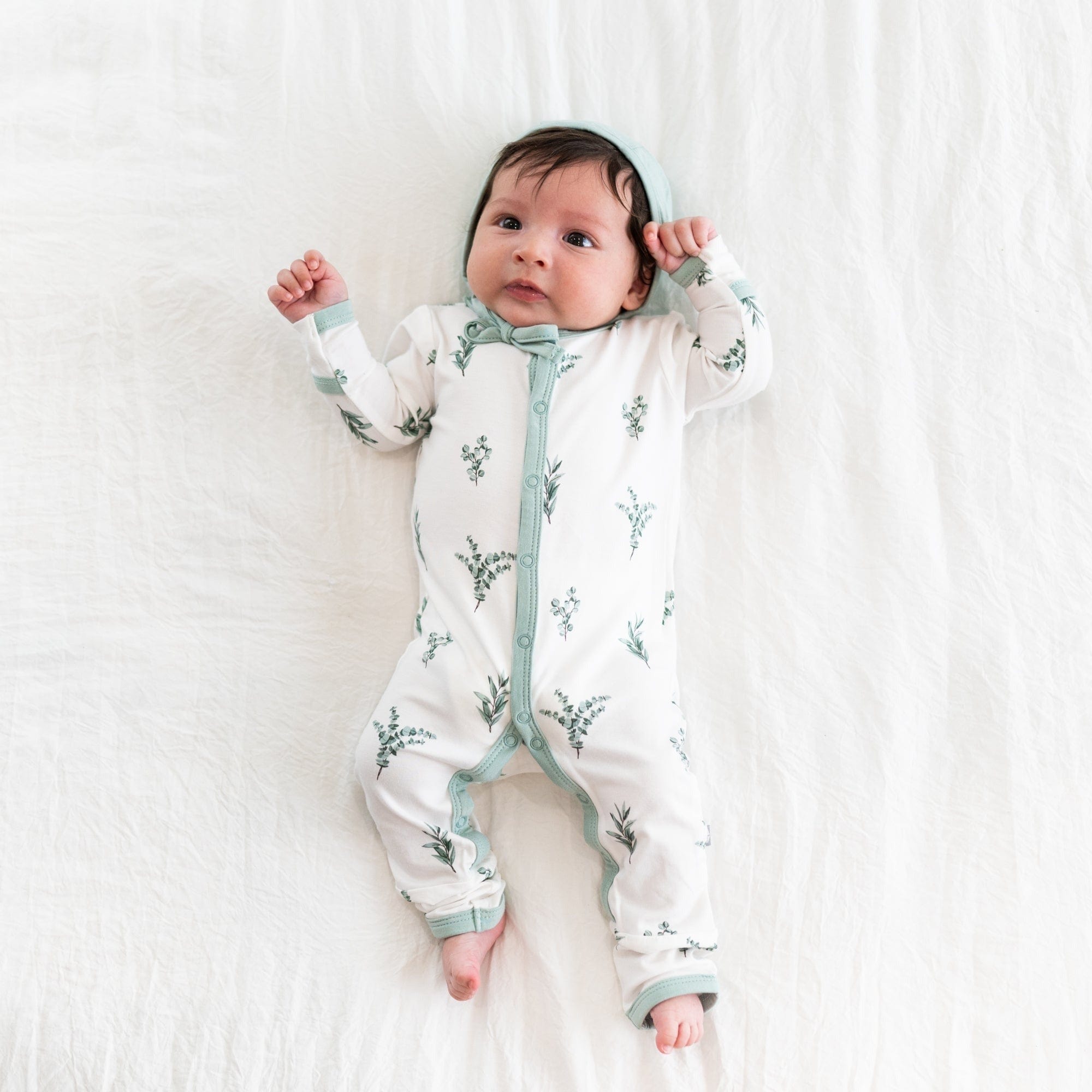 Child wearing long sleeve Kyte Baby Romper with snaps in Eucalyptus