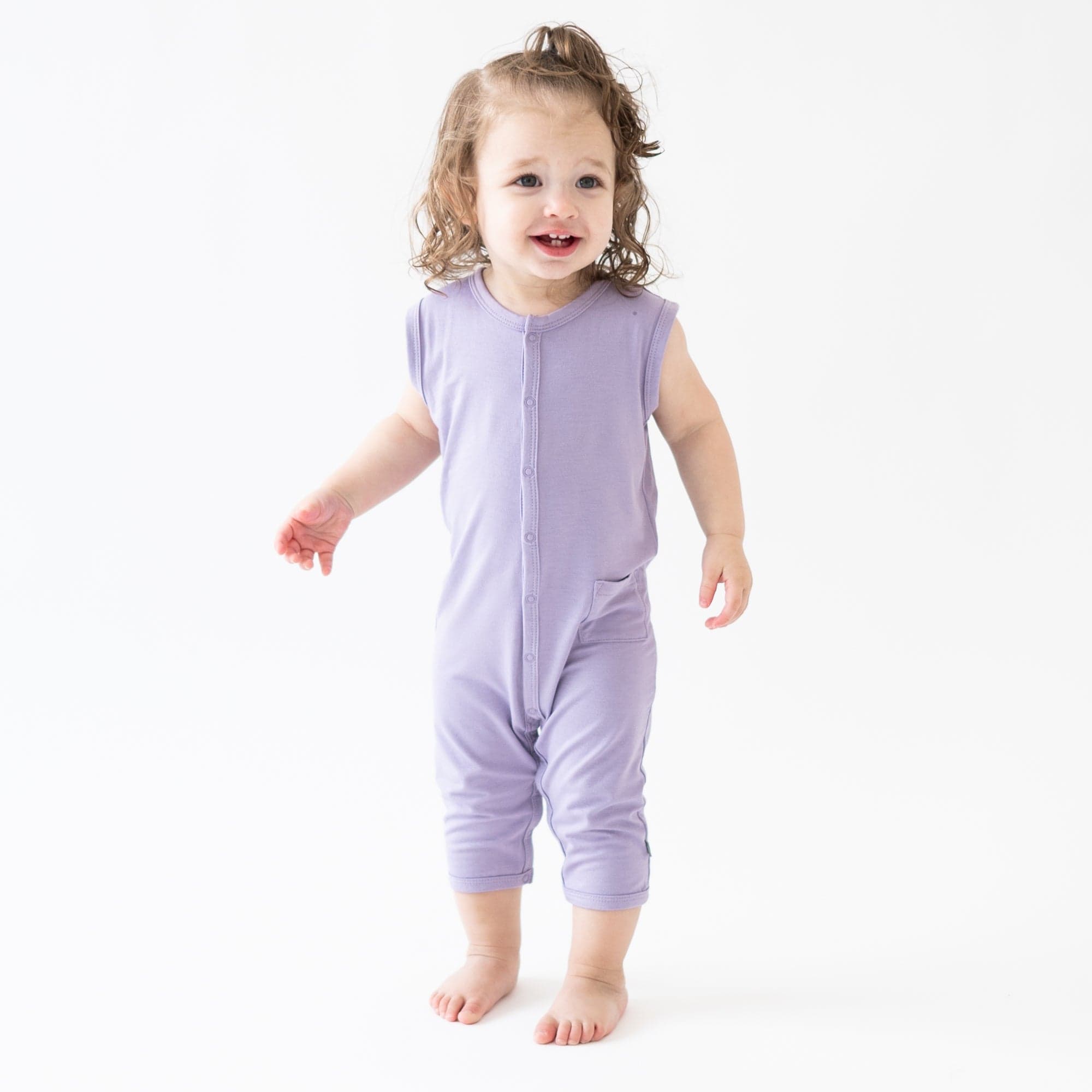 Toddler wearing Kyte Baby Sleeveless capri Romper in Taro