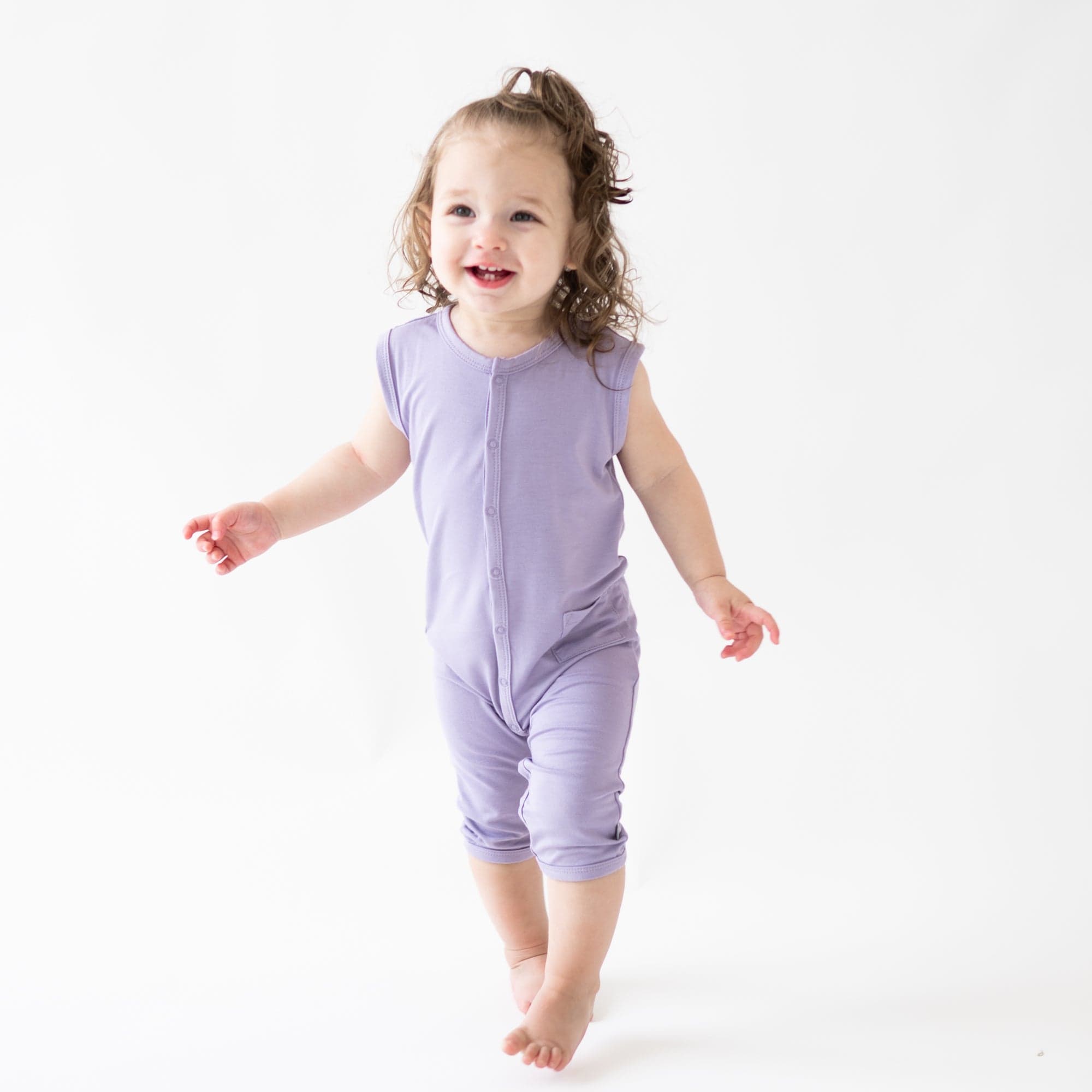 Child wearing bamboo Kyte Baby Sleeveless Romper in Taro