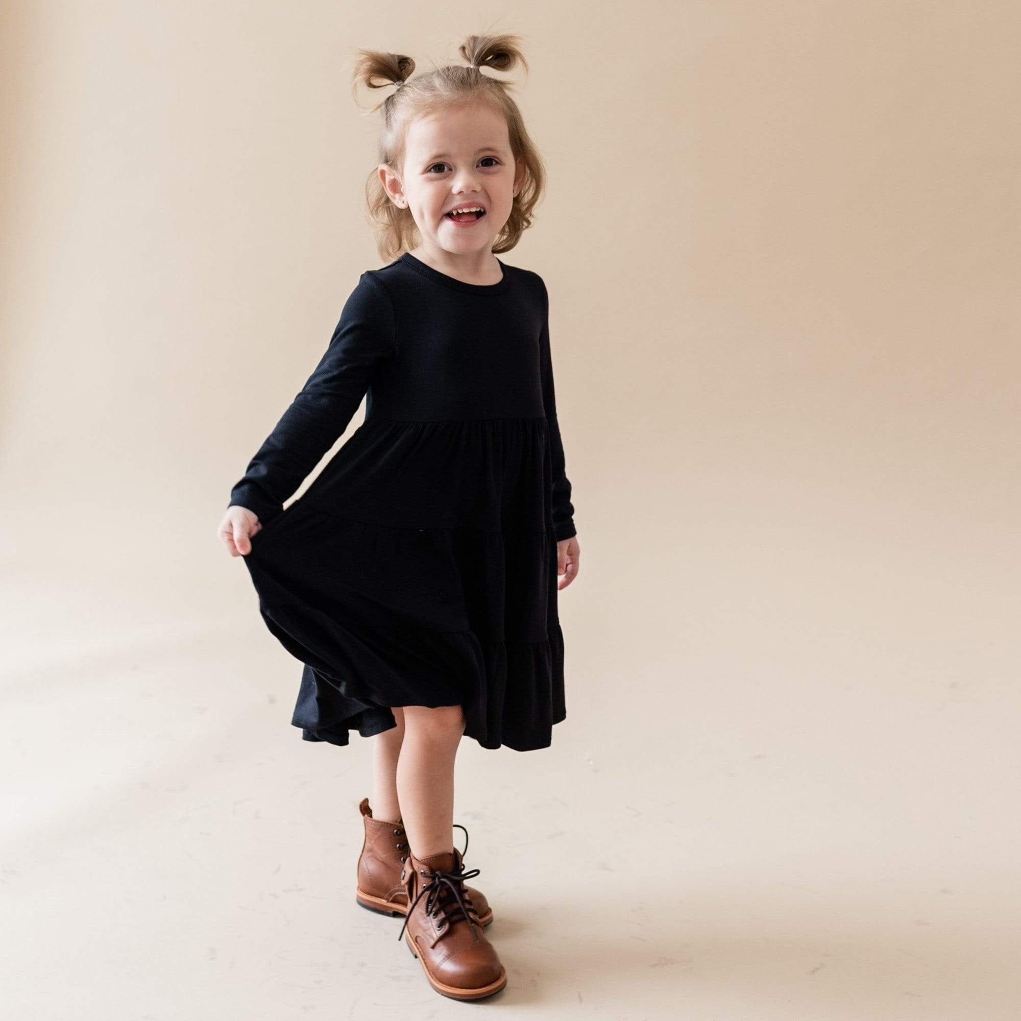 Girl wearing Kyte Baby Long Sleeve Tiered Dress in Midnight