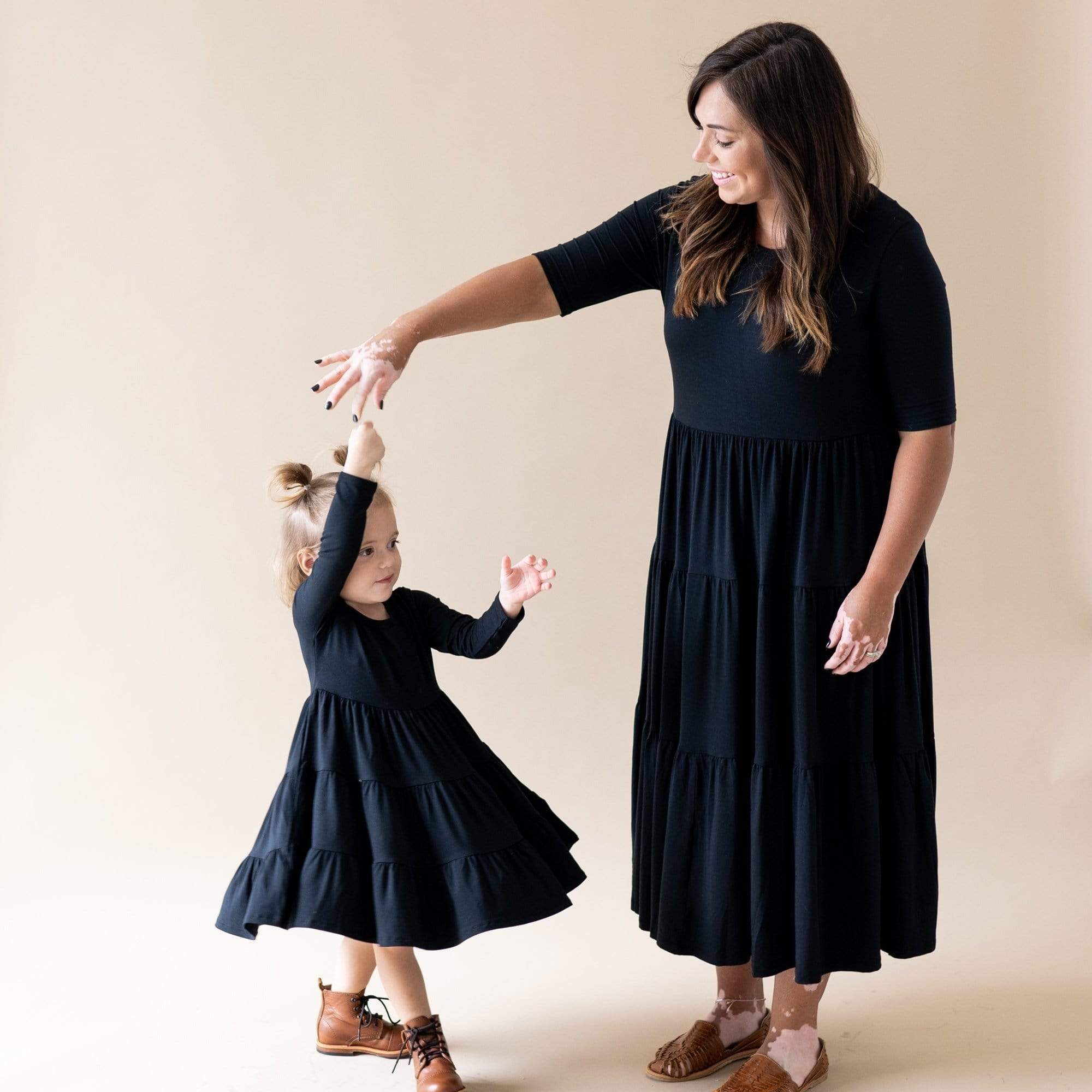 Mom and daughter wearing Kyte Baby matching mommy and me tiered dresses in Midnight
