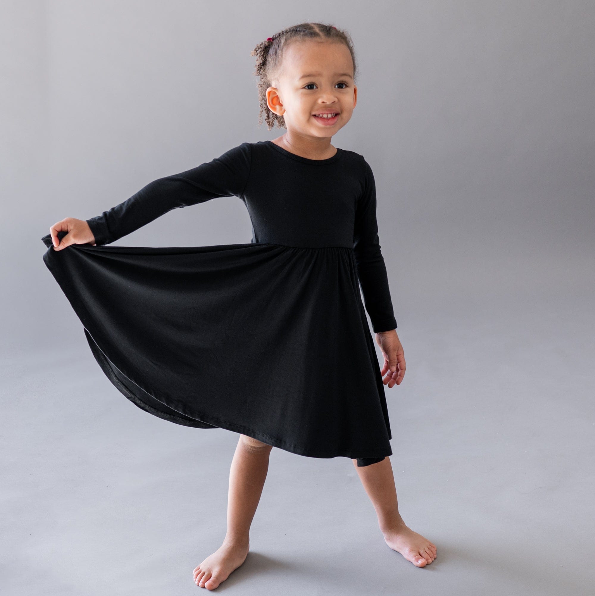 Girl wearing Kyte Baby Long Sleeve Twirl Dress in Midnight