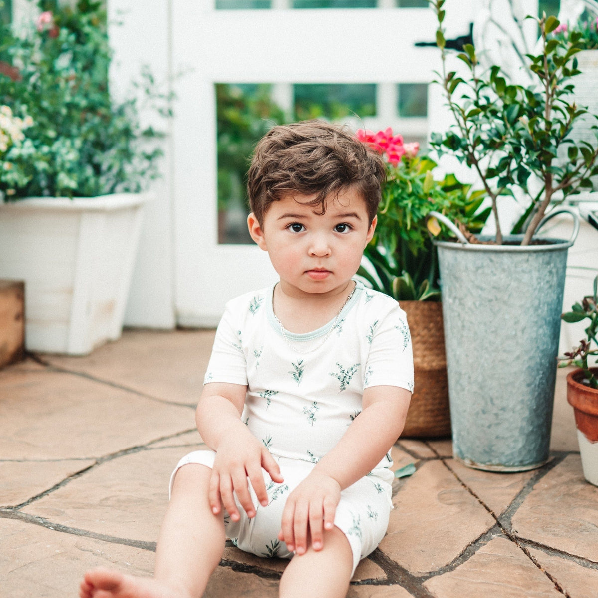 Child wearing Kyte Baby Short Sleeve Pajamas in Eucalyptus
