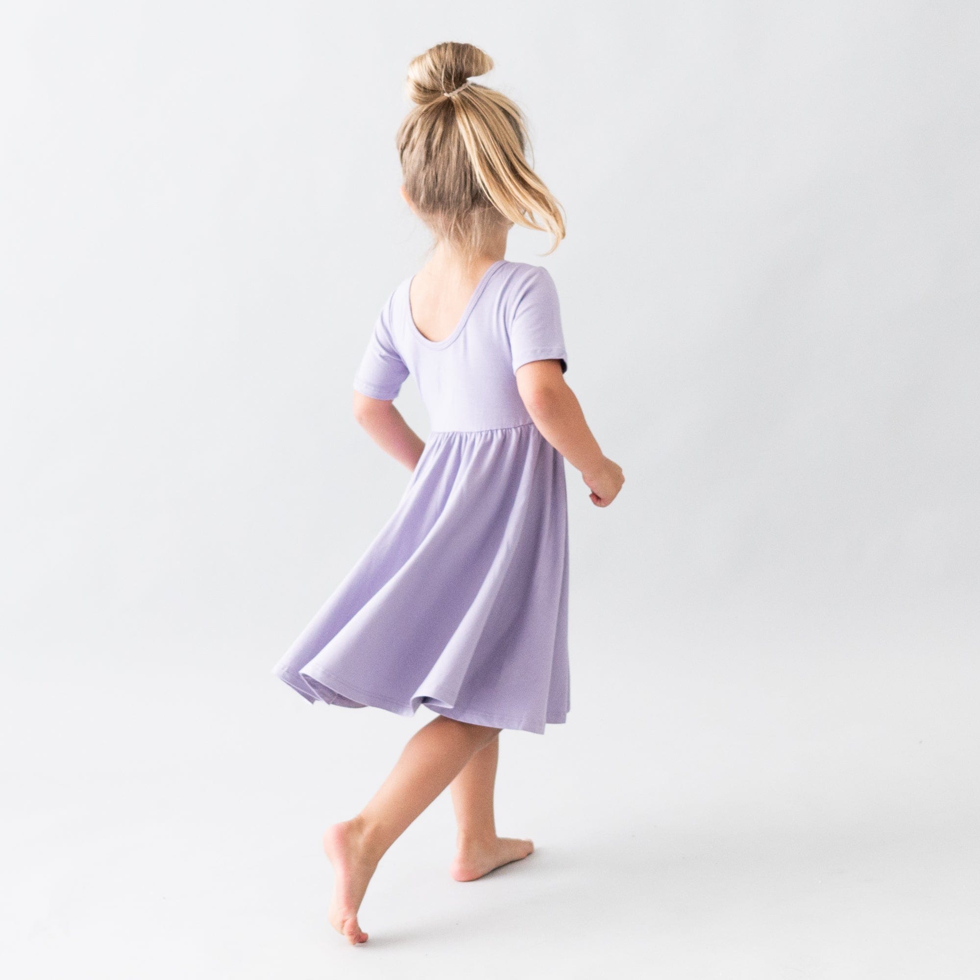 Child mid-spin while wearing a Twirl Dress in Taro