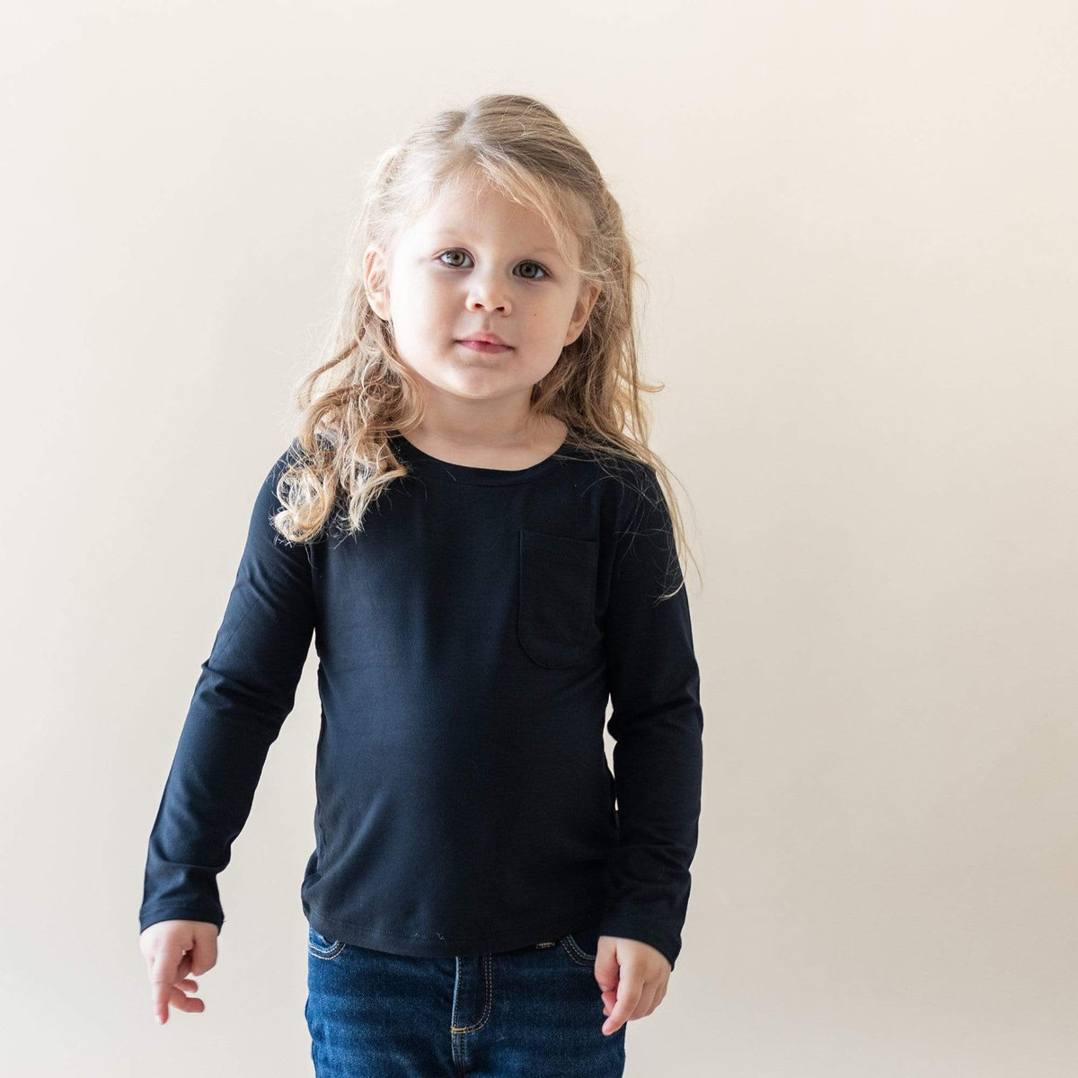 Girl wearing Kyte Baby bamboo Long Sleeve Toddler Crew Neck Tee in Midnight