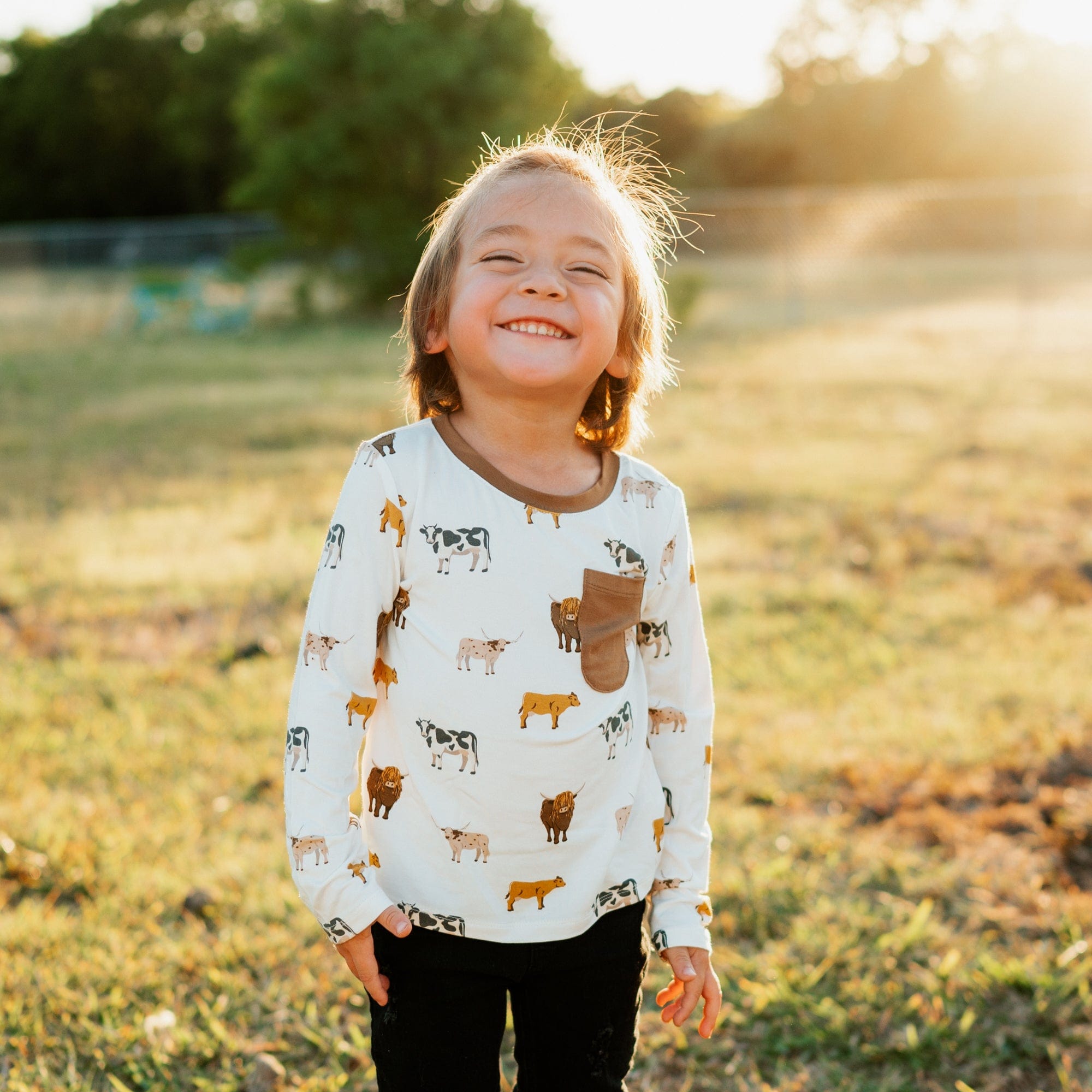 Toddler wearing Kyte Baby Long Sleeve Crew Neck Tee with pocket in Moo