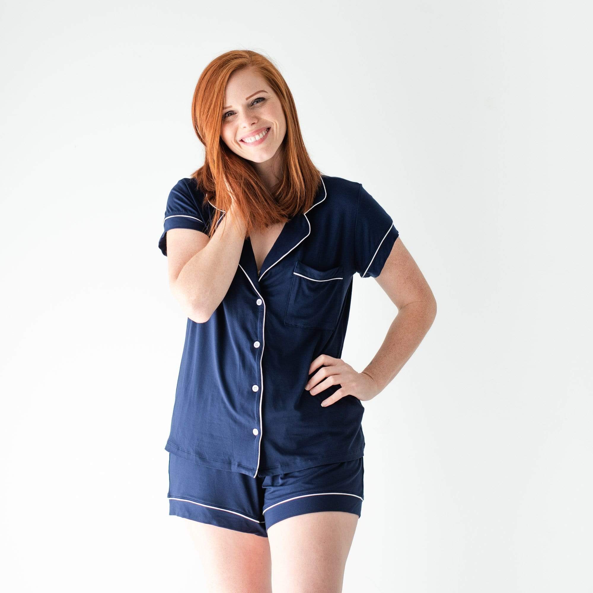 Woman wearing Kyte Baby bamboo Short Sleeve Pajama Set in Navy with Cloud Trim