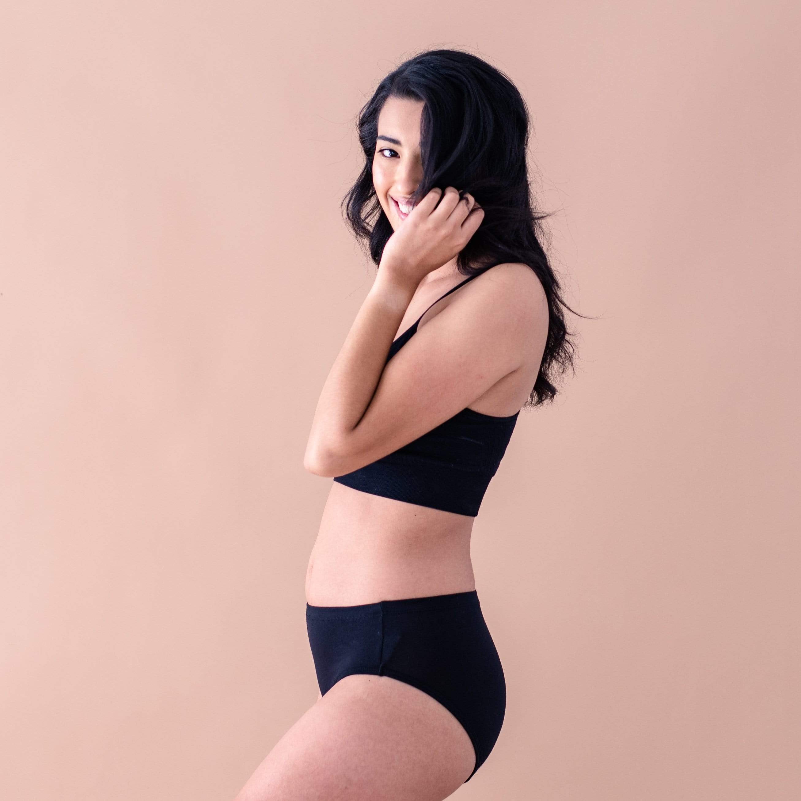 Woman wearing Kyte Baby Women's bamboo underwear and bra in Midnight