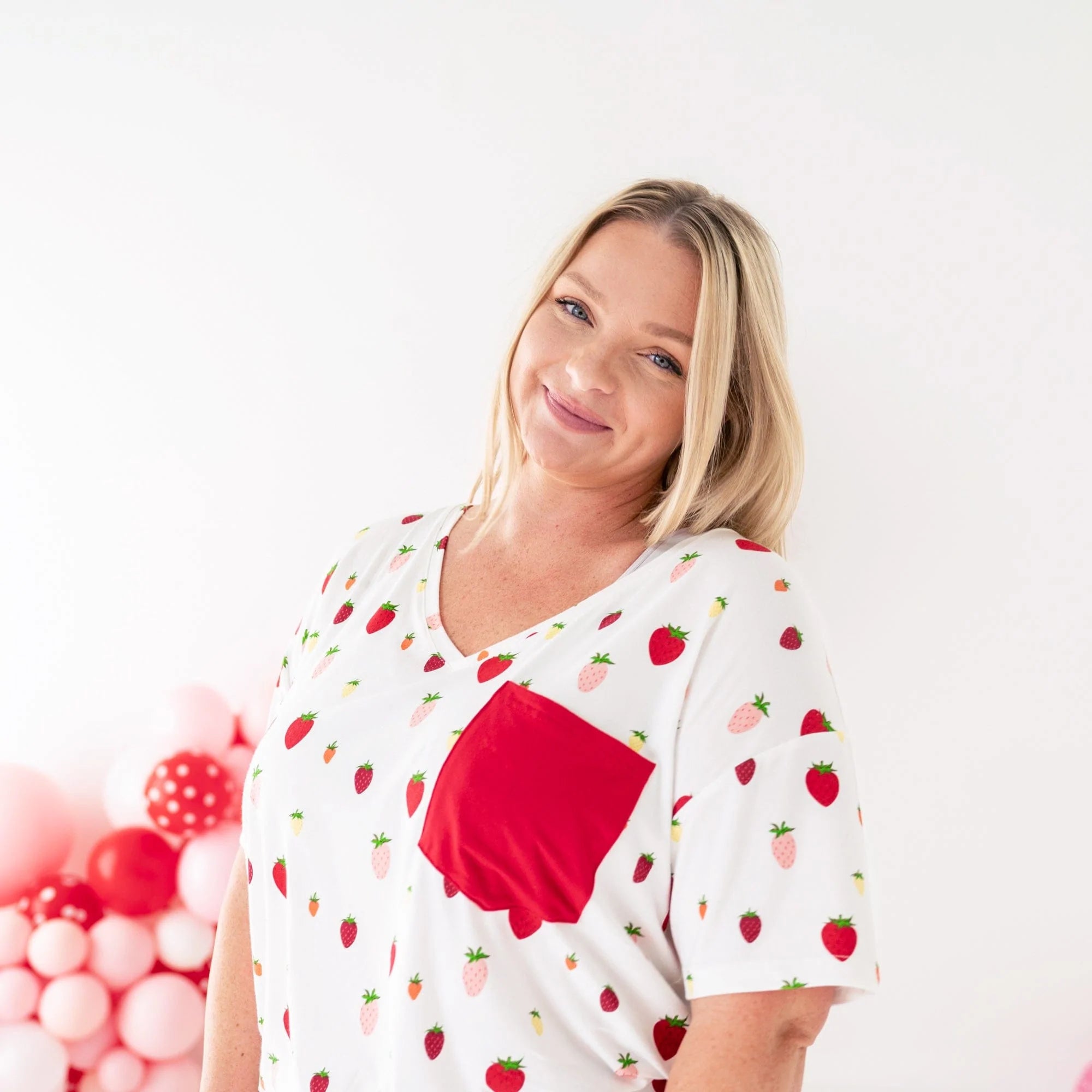 Woman wearing Kyte Baby Women's Relaxed Fit V-Neck tee in Strawberry with red pocket