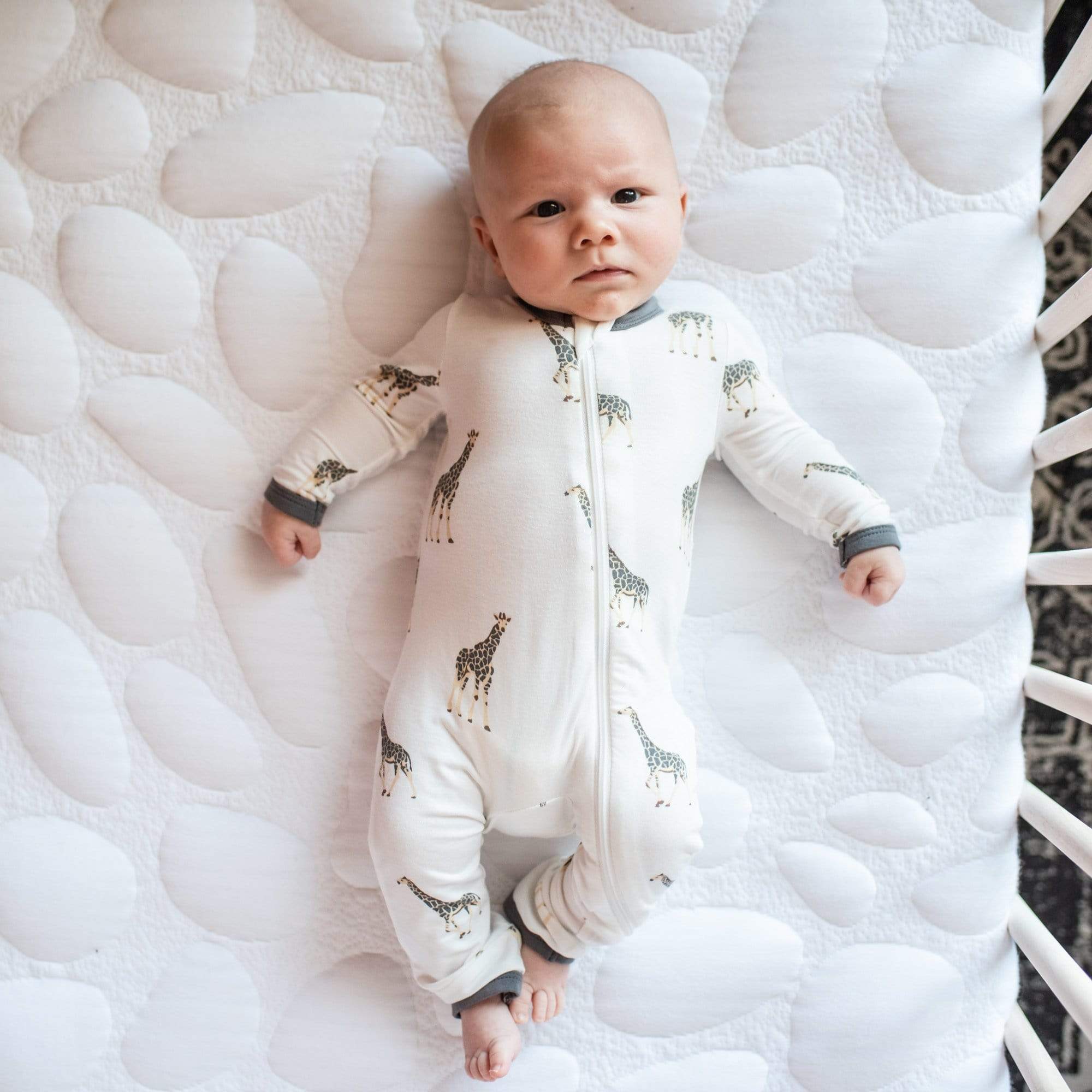 Infant wearing Kyte Baby Zippered Romper in Giraffe