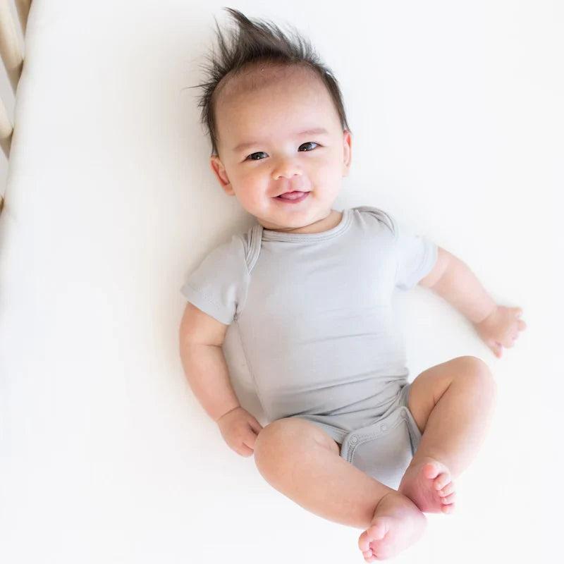 Baby wearing gray bodysuit