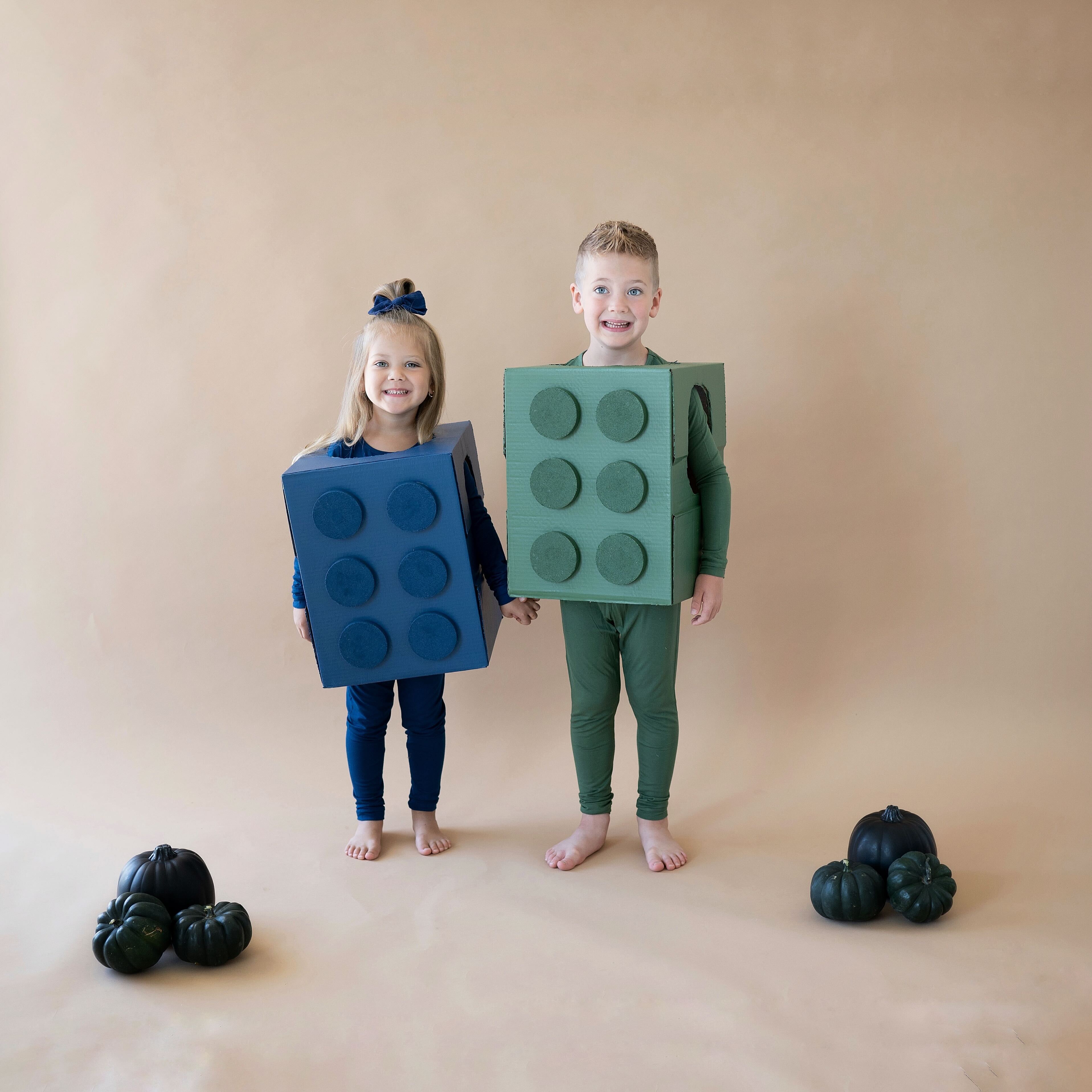 two children dressed up as Legos for Halloween, wearing Kyte Baby pajamas
