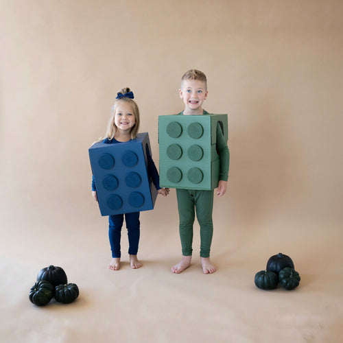 Siblings dressed up as Lego for Halloween wearing Kyte Baby pajamas