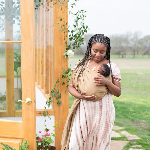 mom smiling down at baby in kyte baby flax ring sling