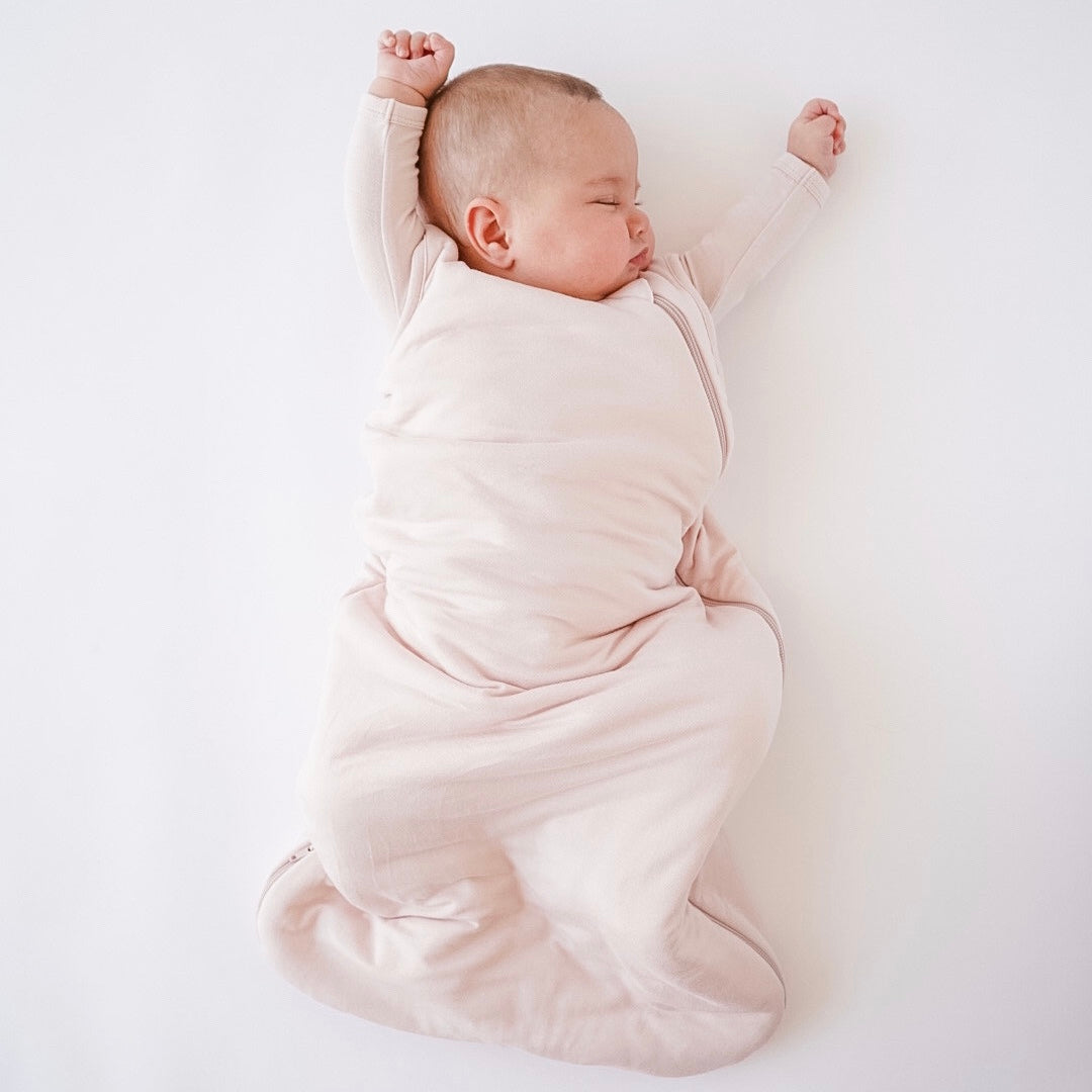 baby sleeping with arms up in a kyte baby sleep bag