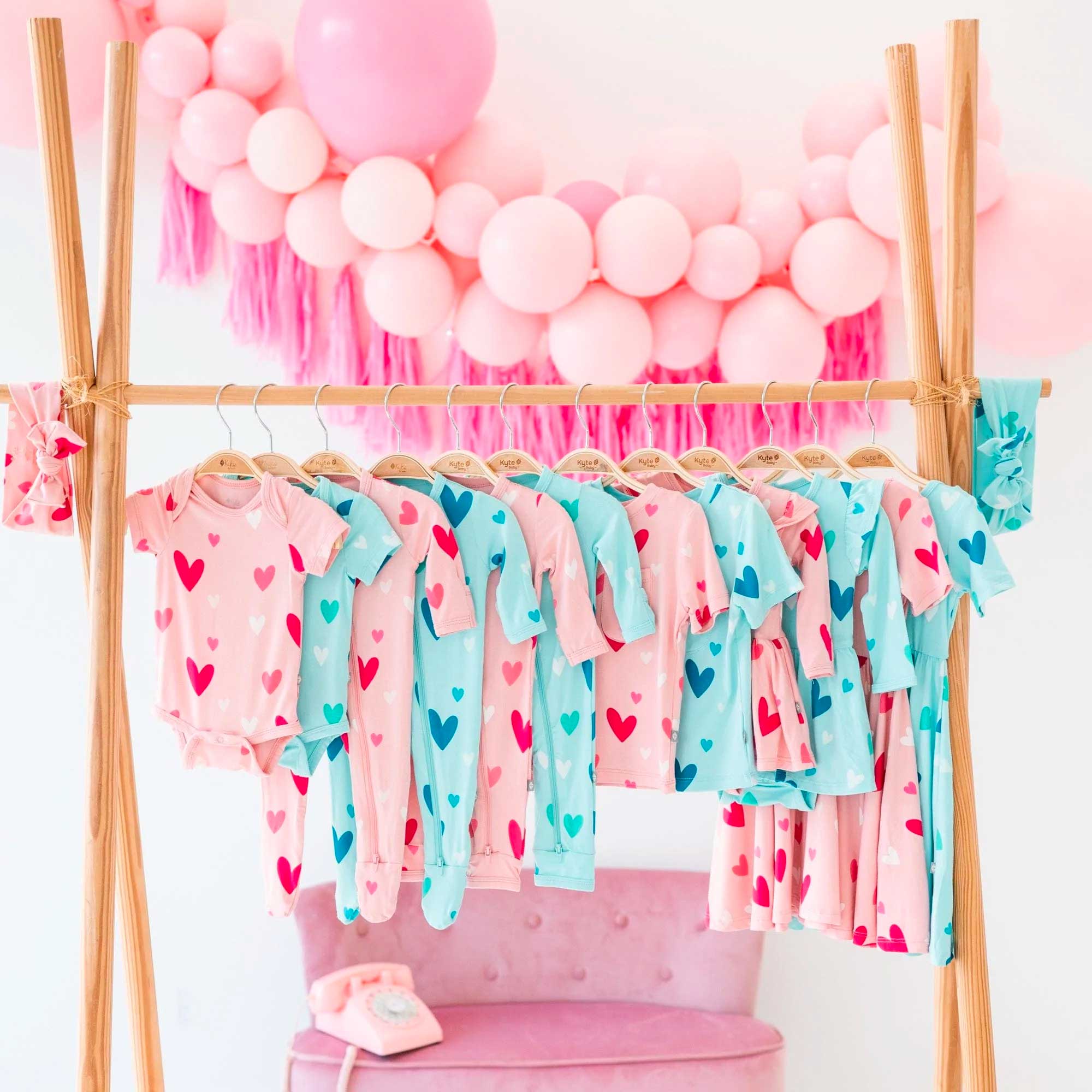 kyte baby valentine's day collection hanging on a rack with balloons