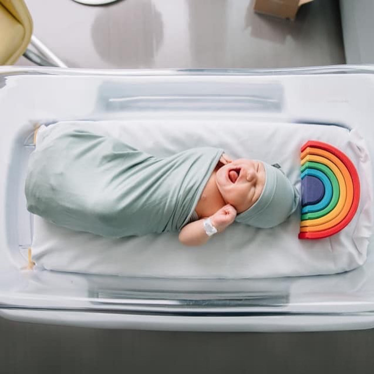 newborn baby wrapped in a swaddle in the hospital
