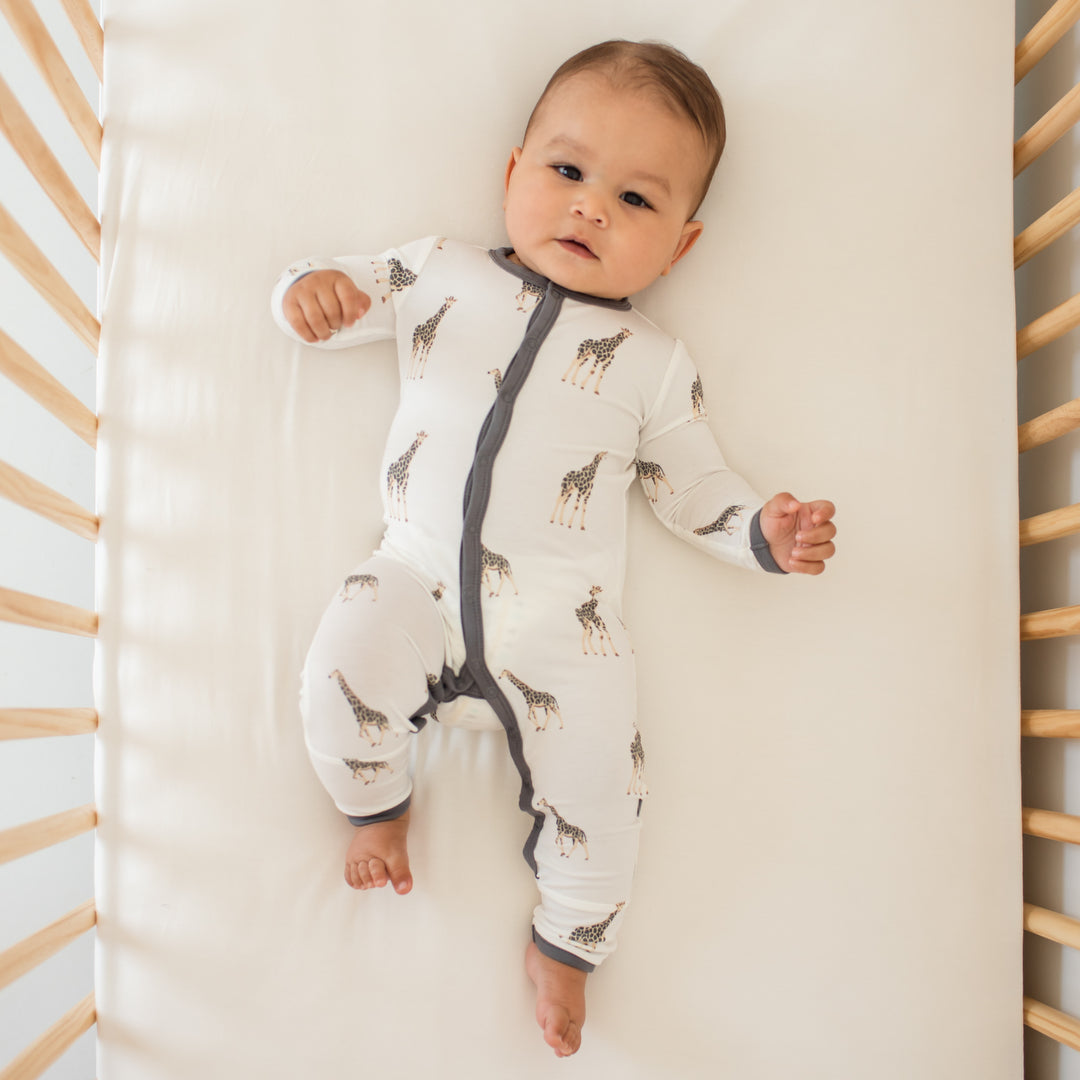 Infant wearing Kyte Baby giraffe pajamas