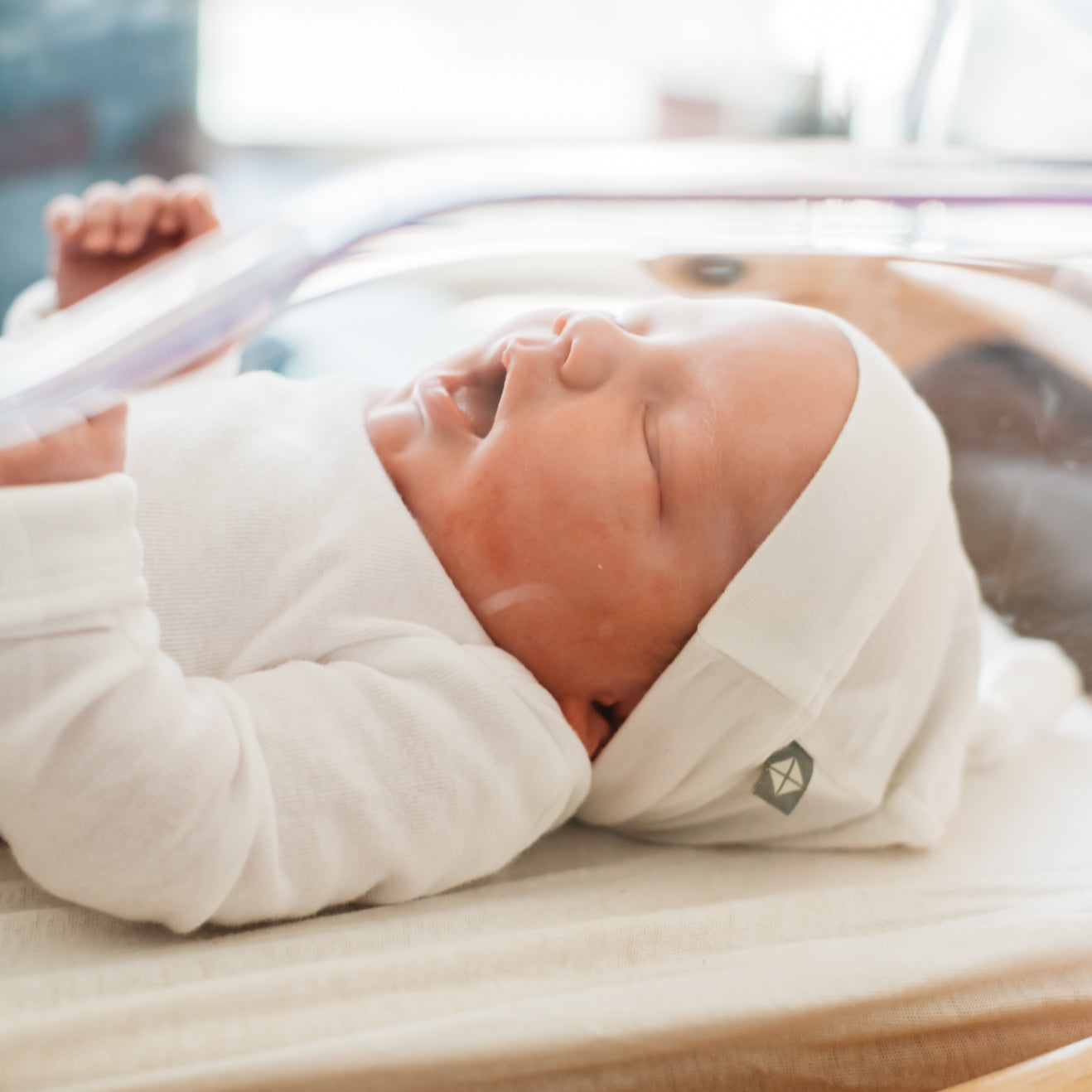 newborn baby in the hospital wearing a onesie and a hat