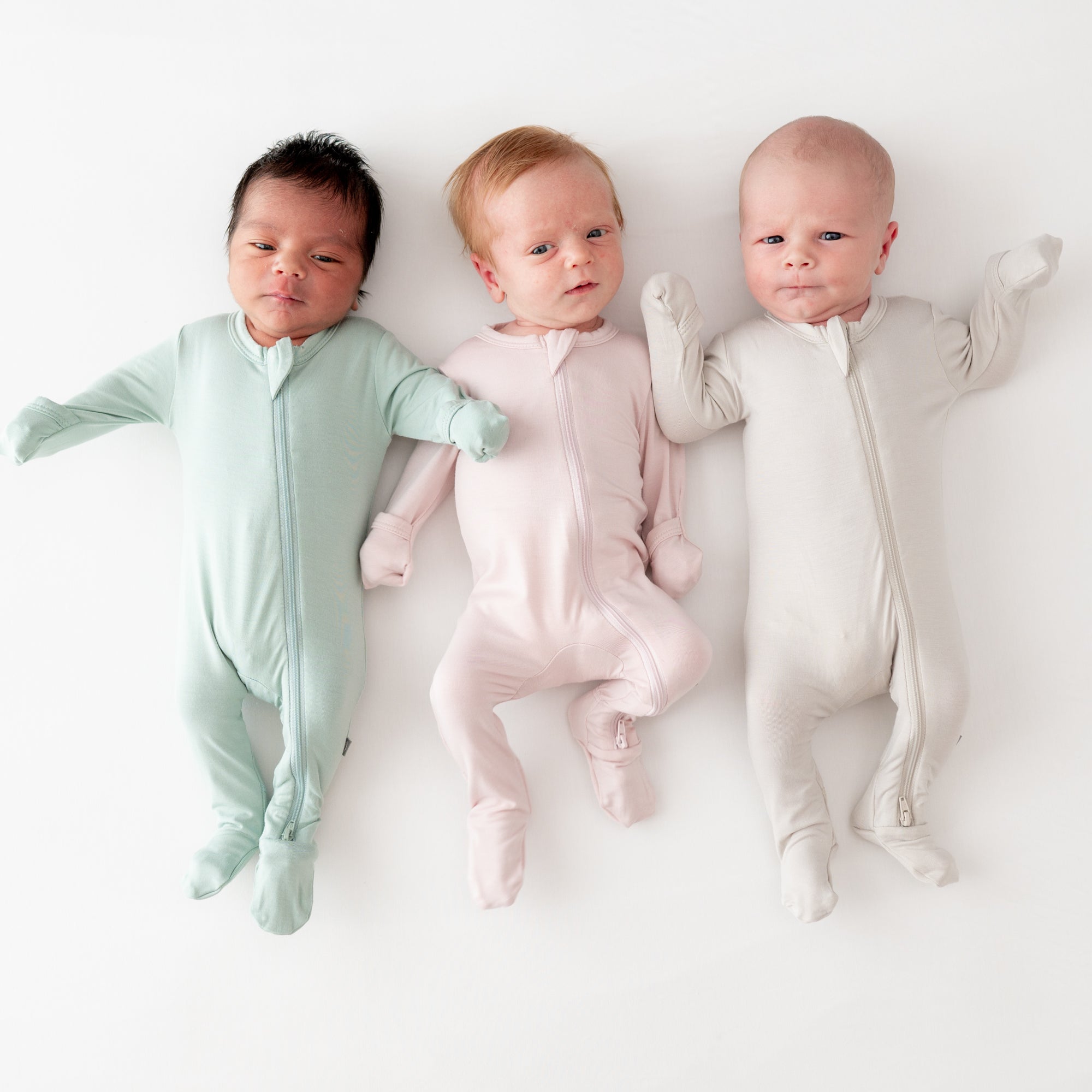 three babies wearing kyte baby footies
