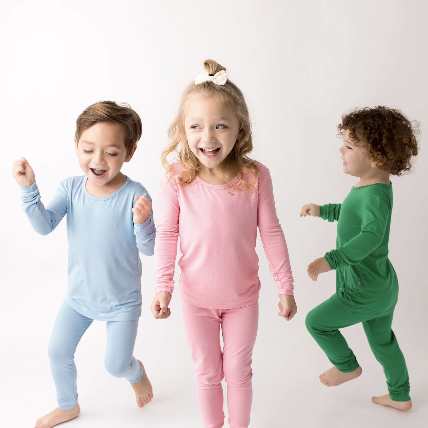 toddlers wearing kyte baby long sleeve pajamas in spring colors stream, rose, and fern