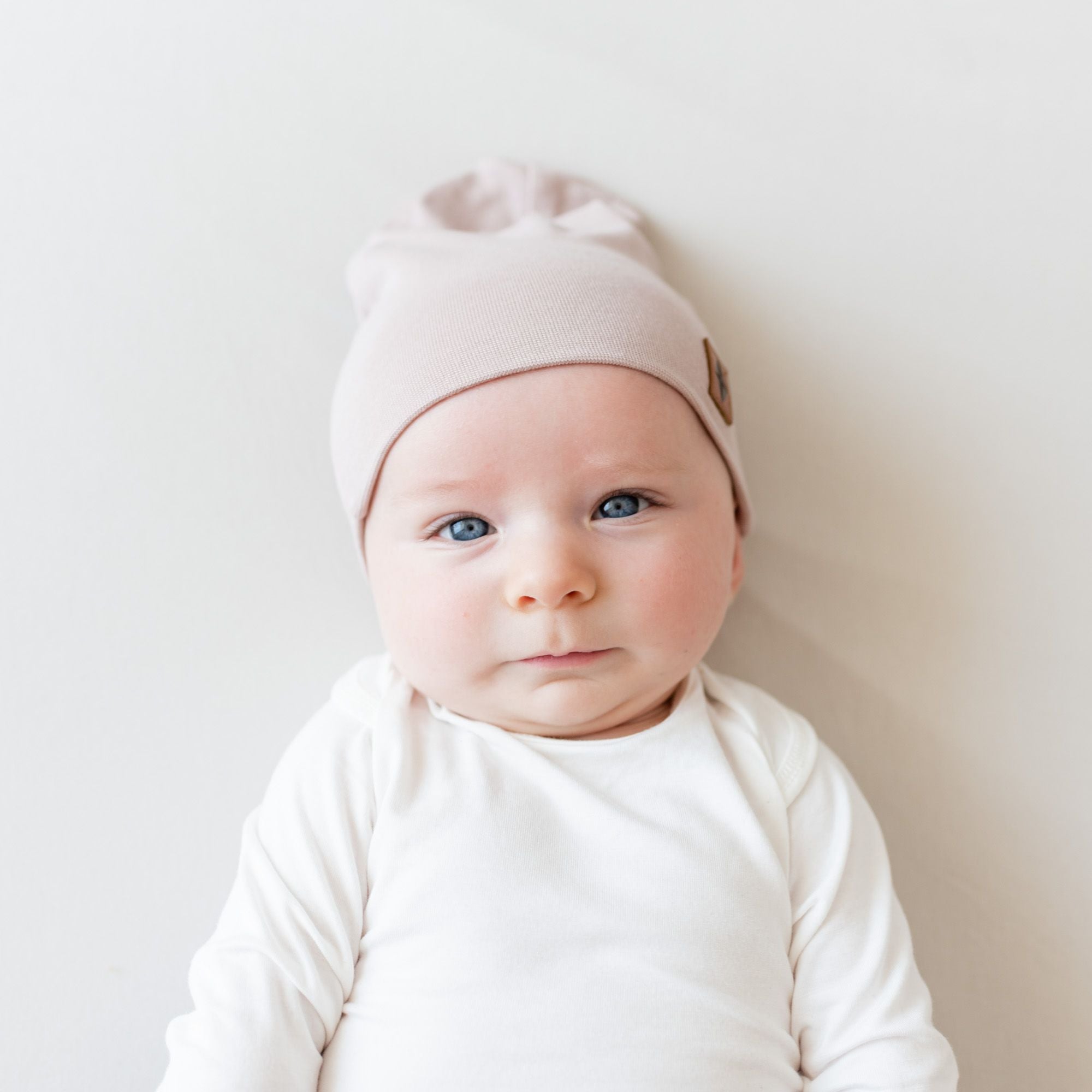 Baby wearing bamboo jersey beanie in the color sunset