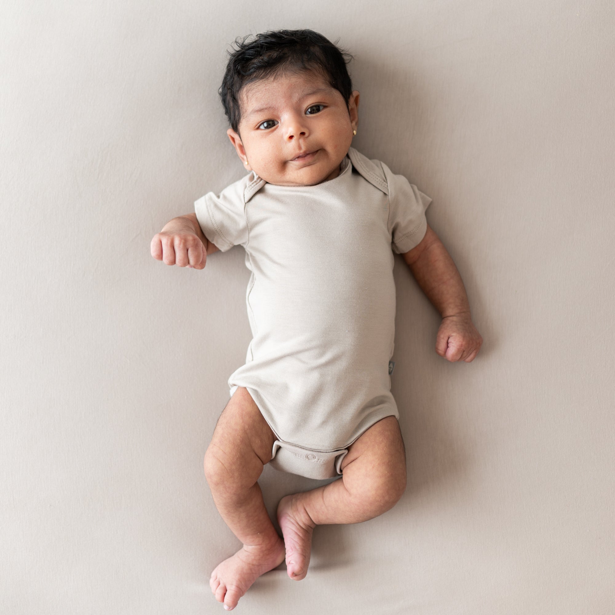 Baby modelling khaki bodysuit