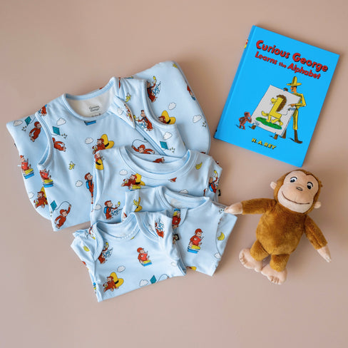 Curious George and Kyte collaboration graphic on a light blue background, featuring the Curious George logo, Kyte logo, a green kite, banana, and cloud with the cartoon monkey flying.