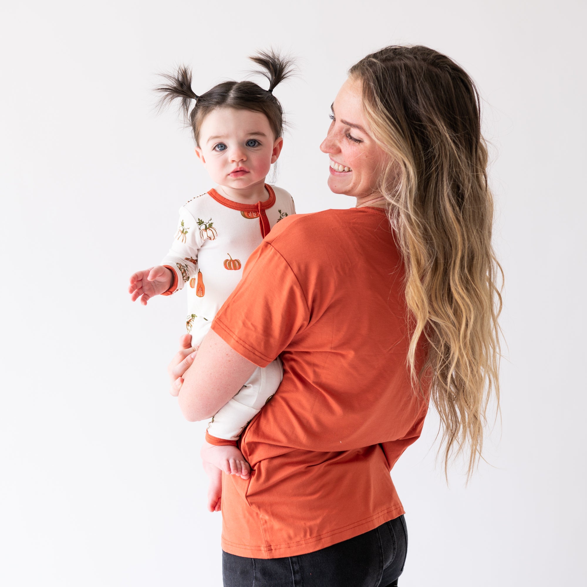 Mom wearing Clementine V-Neck Shirt Holding Baby Wearing a Snap Pumpkin Romper