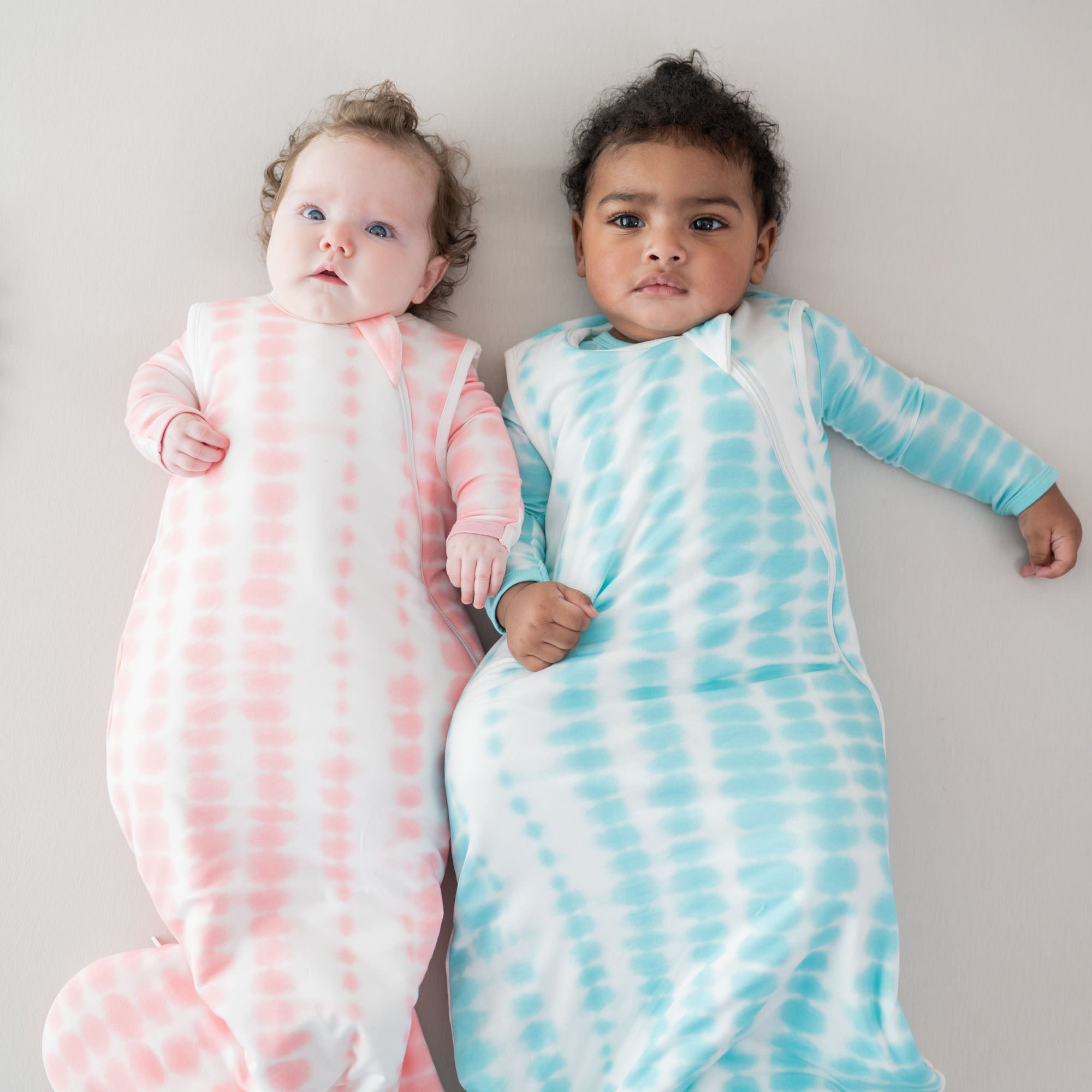 babies wearing a romper and sleep bags 