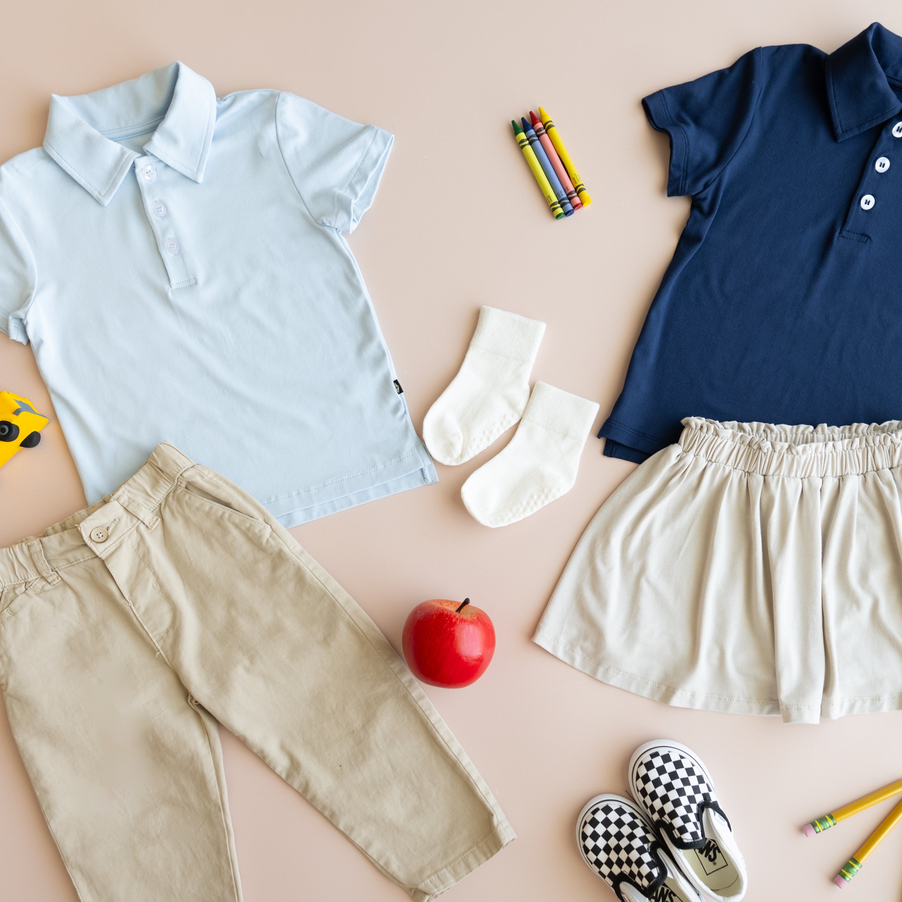 Flat lay of kyte baby polo styles, back to school props and kid accessories