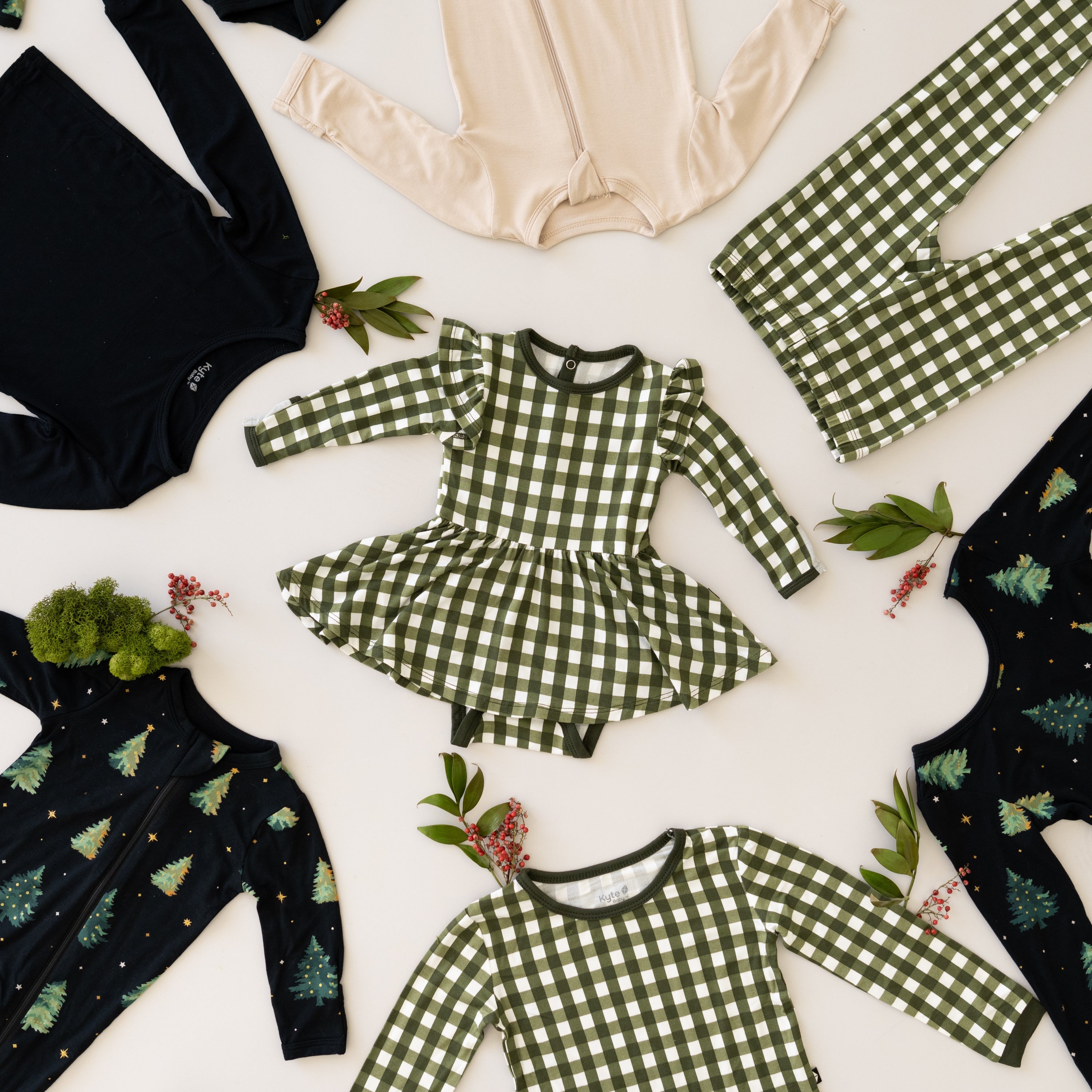flat lay of baby and toddler clothing in holiday prints 