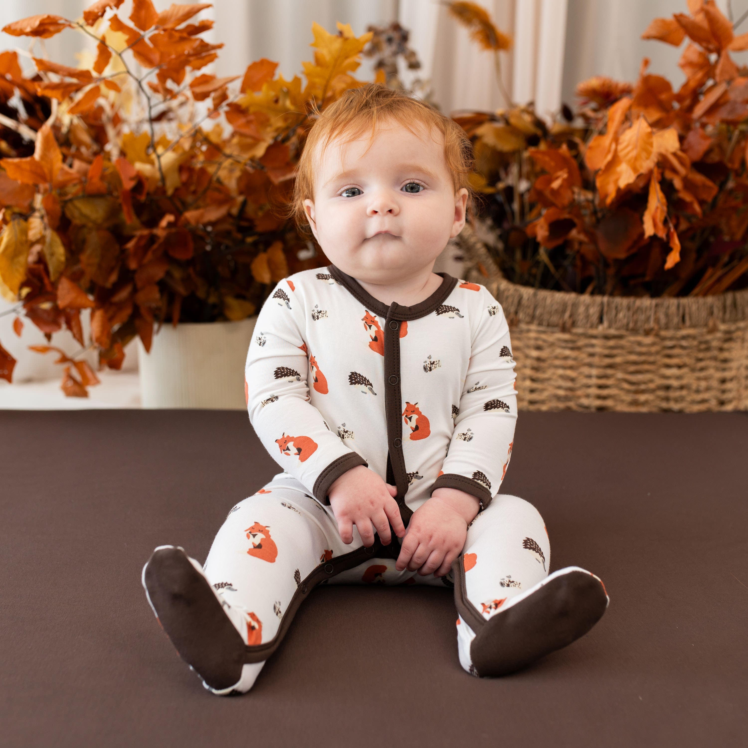 baby wearing button footie in sienna woodland print 