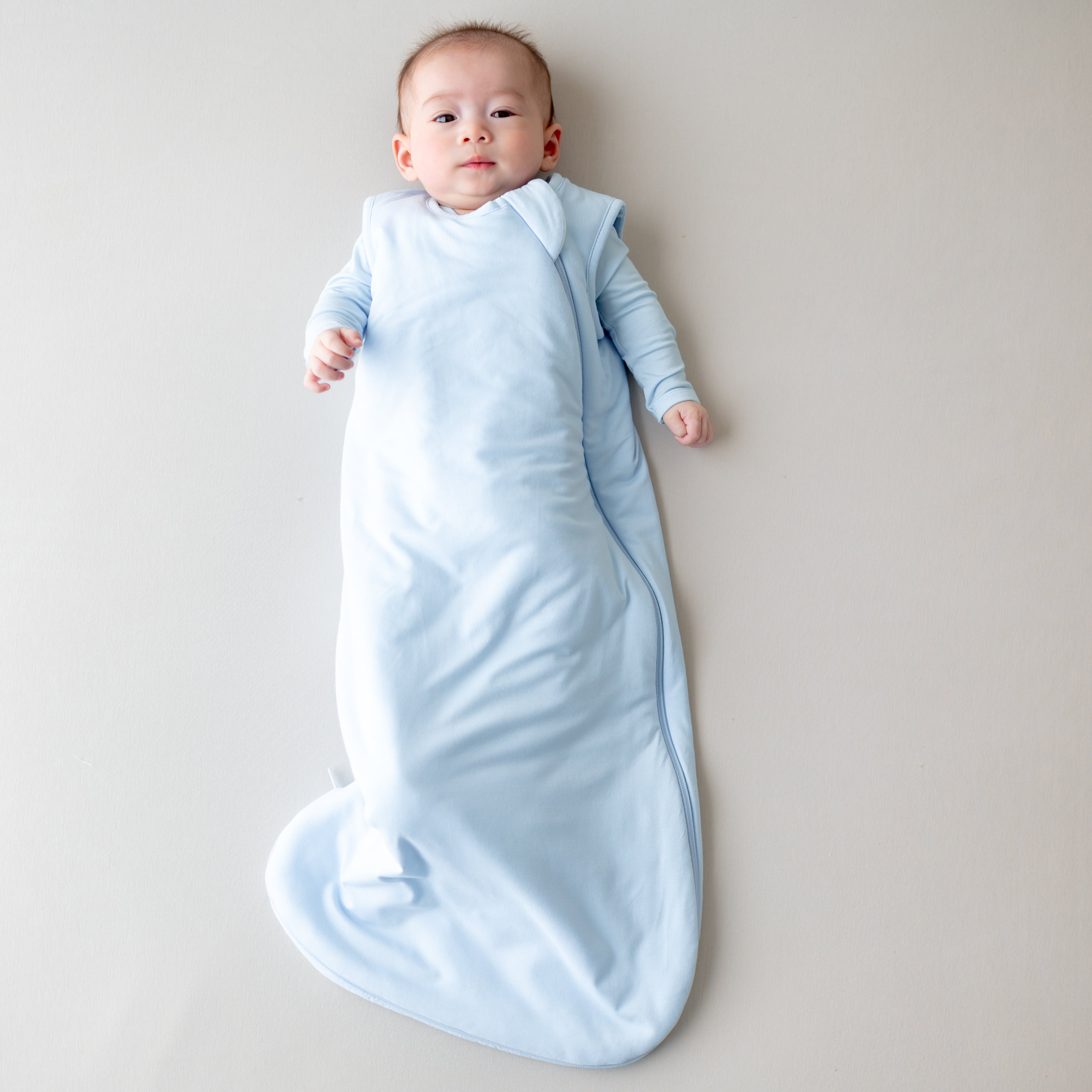 Baby in a light blue 1.0 tog sleep bag