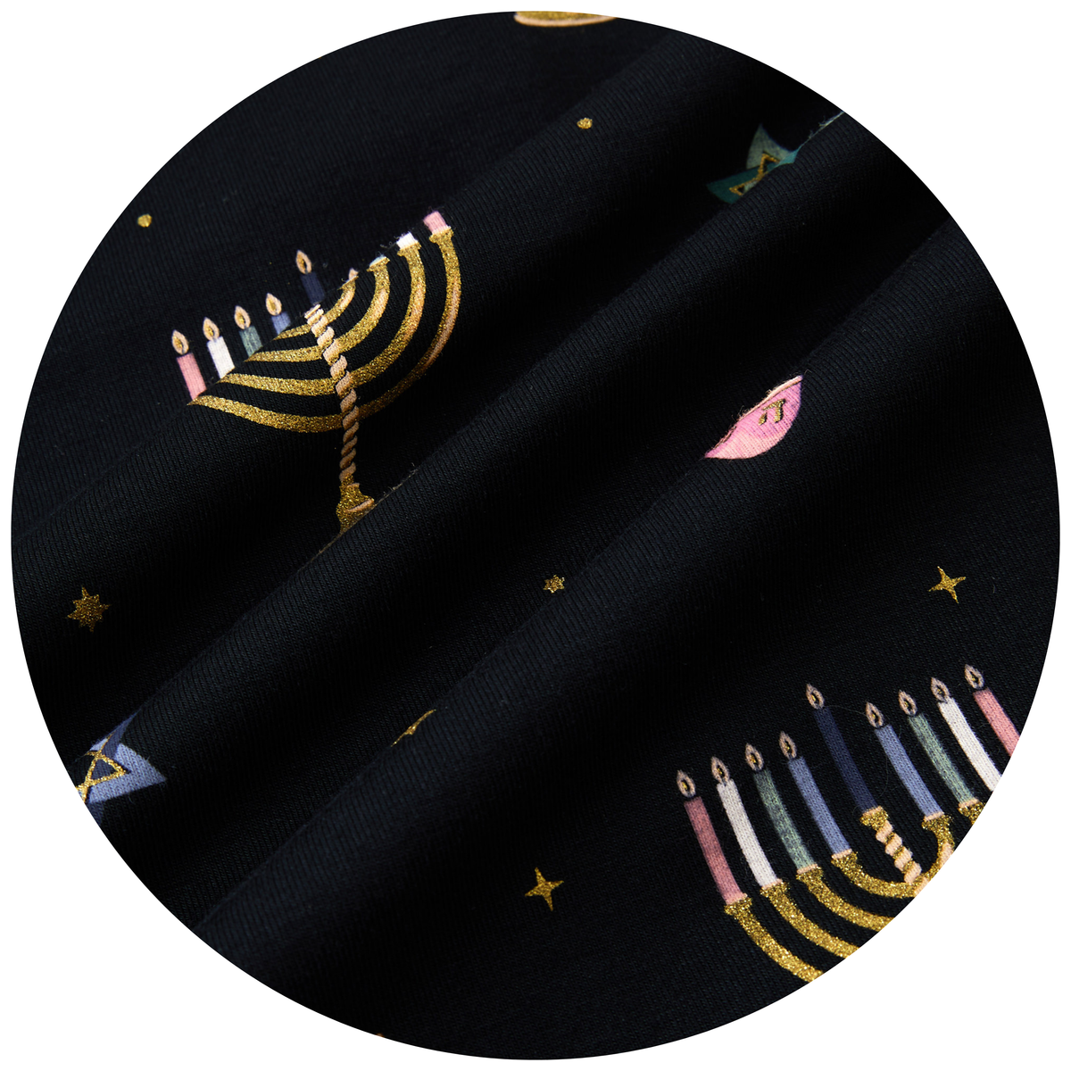 A close-up circular view of black fabric with a printed pattern of gold menorahs, multicolored candles, and small stars.
