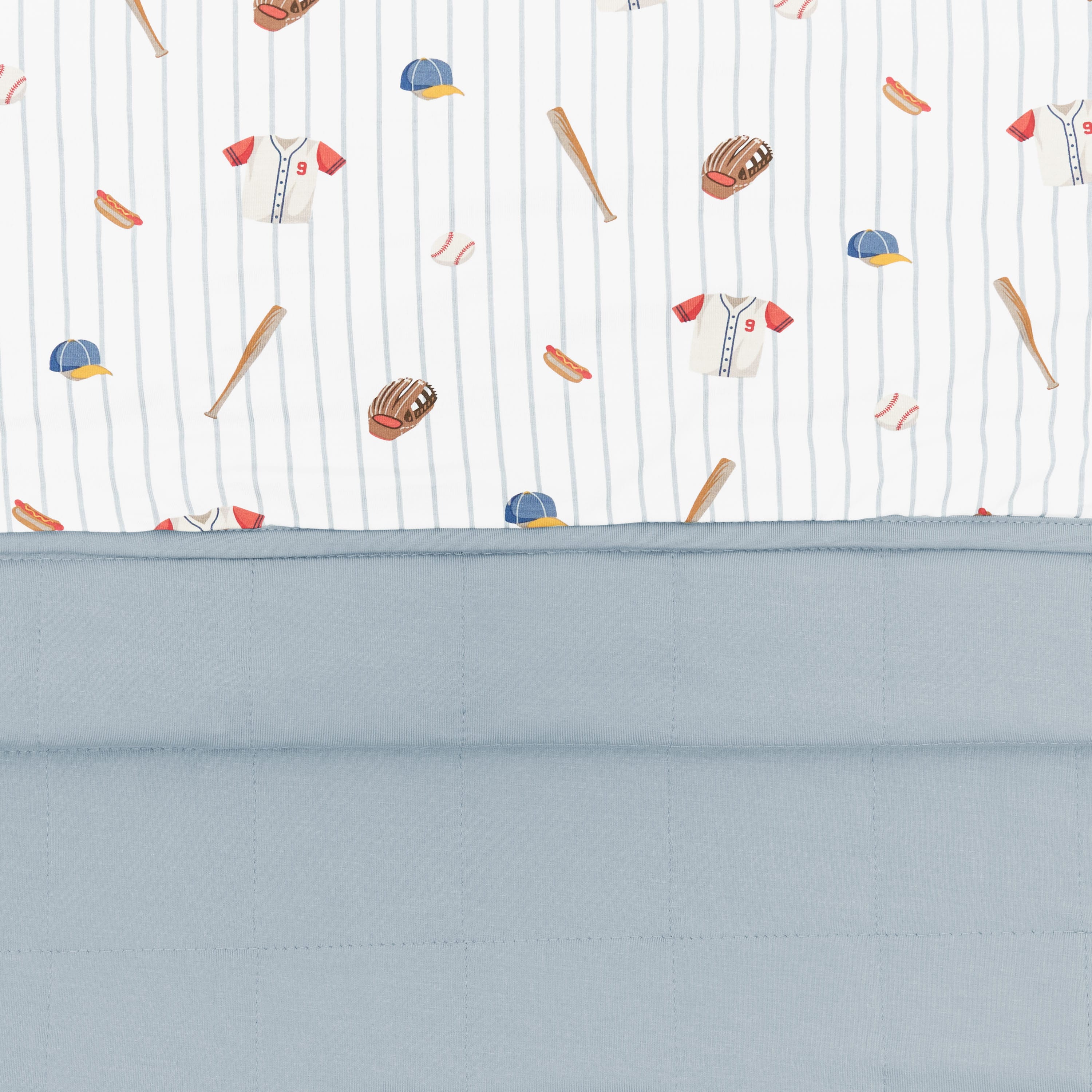 Close up of the Youth Blanket in Home Run 1.0 showing the muted blue quilted backing and smooth baseball print top layer