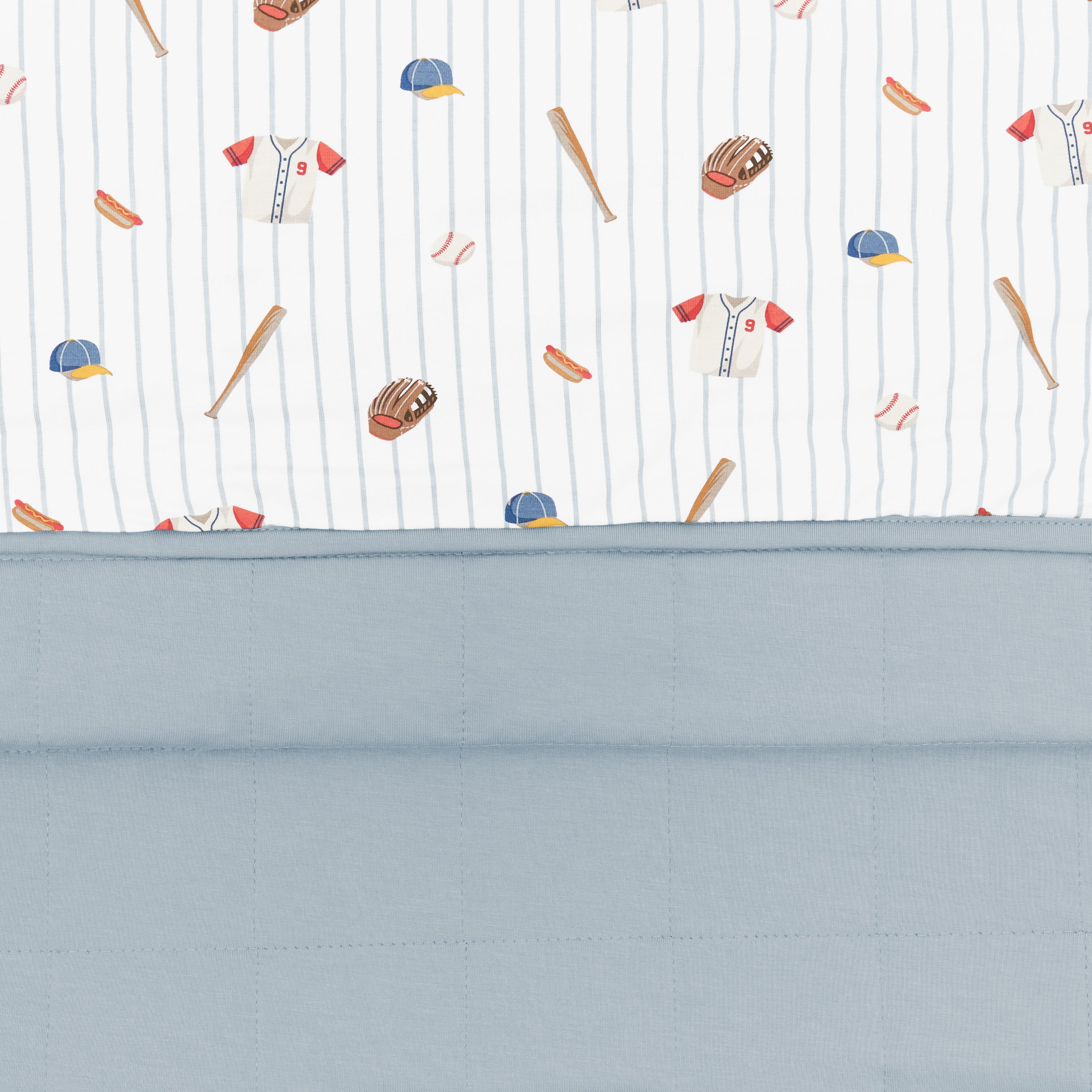 Close up of the Youth Blanket in Home Run 1.0 showing the muted blue quilted backing and smooth baseball print top layer