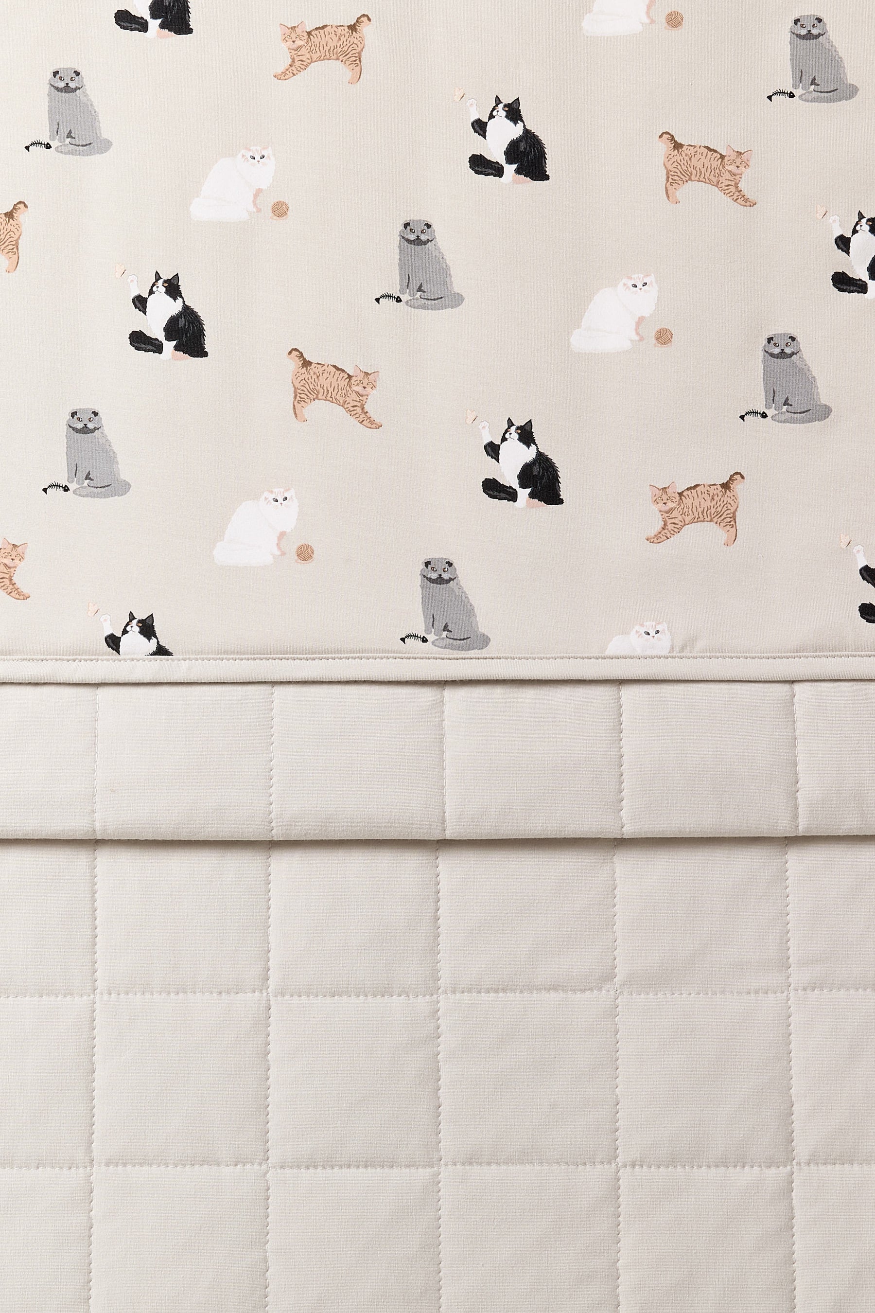 Close up of the Baby Blanket in Fluffy Cat showing the light beige quilted backing and smooth top layer cat print