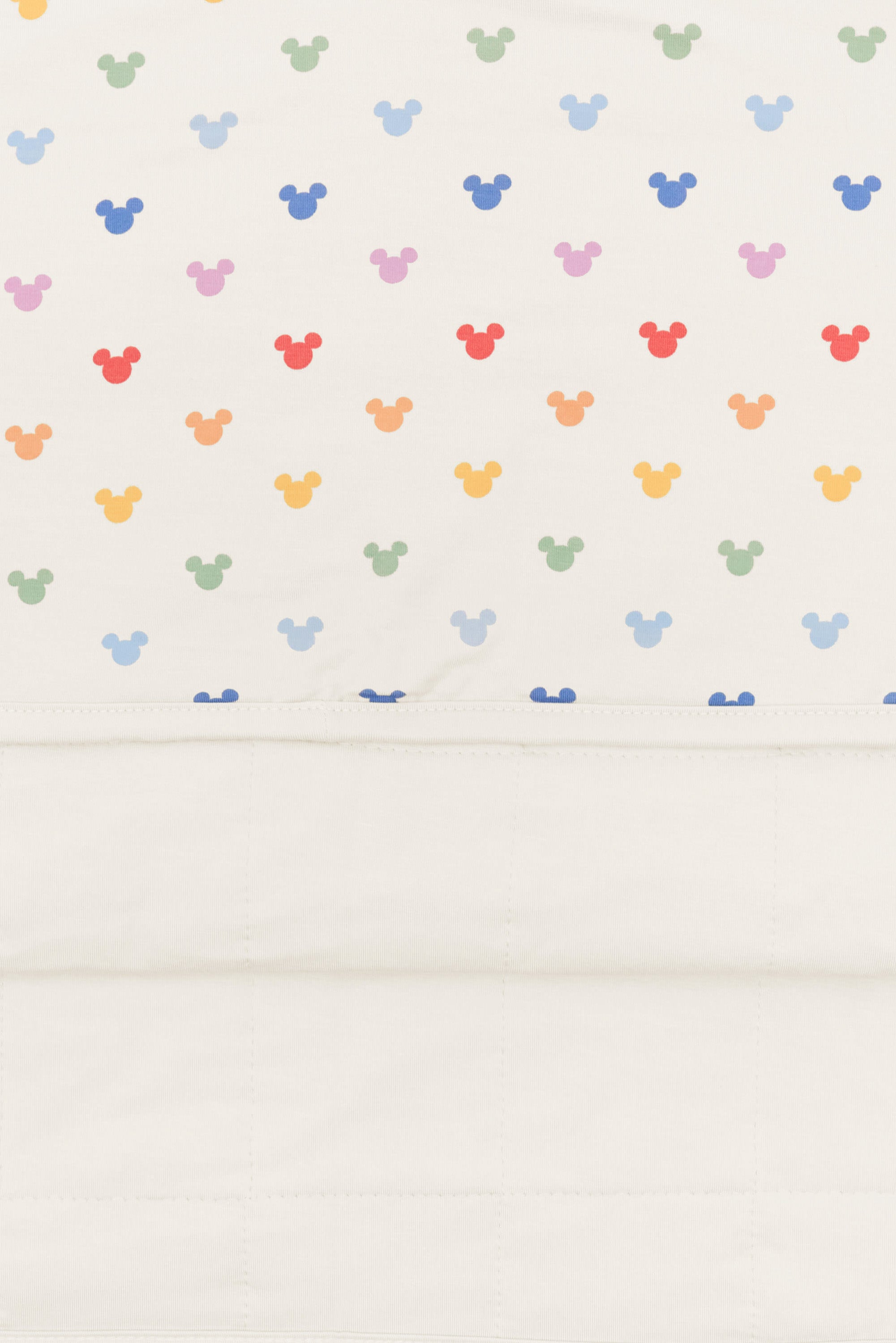 Back side fabric of baby blanket with pastel mickey mouse icons on an oat background