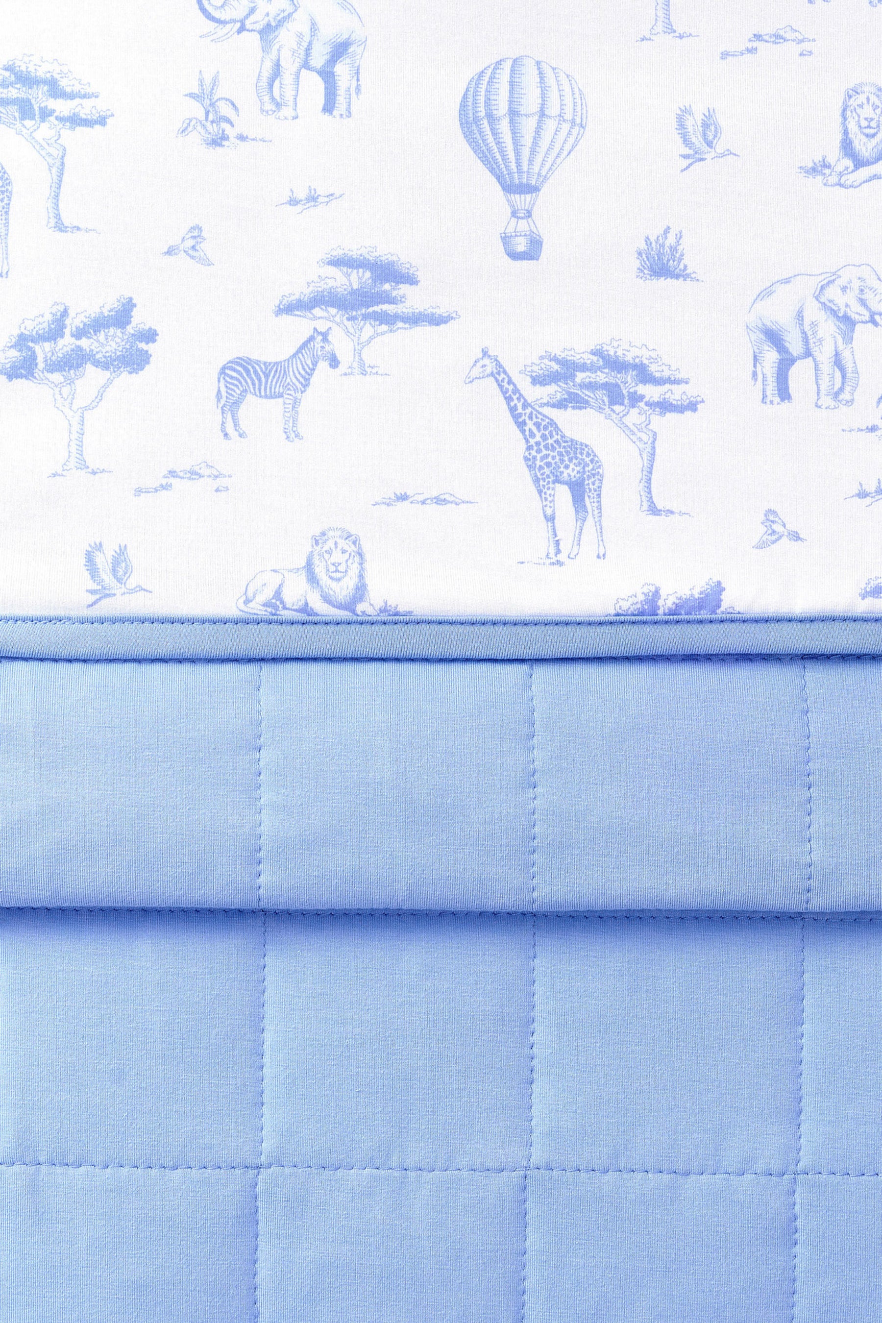 Close up of the Baby Blanket in Toile Safari showing the quilted blue backing and smooth printed top layer