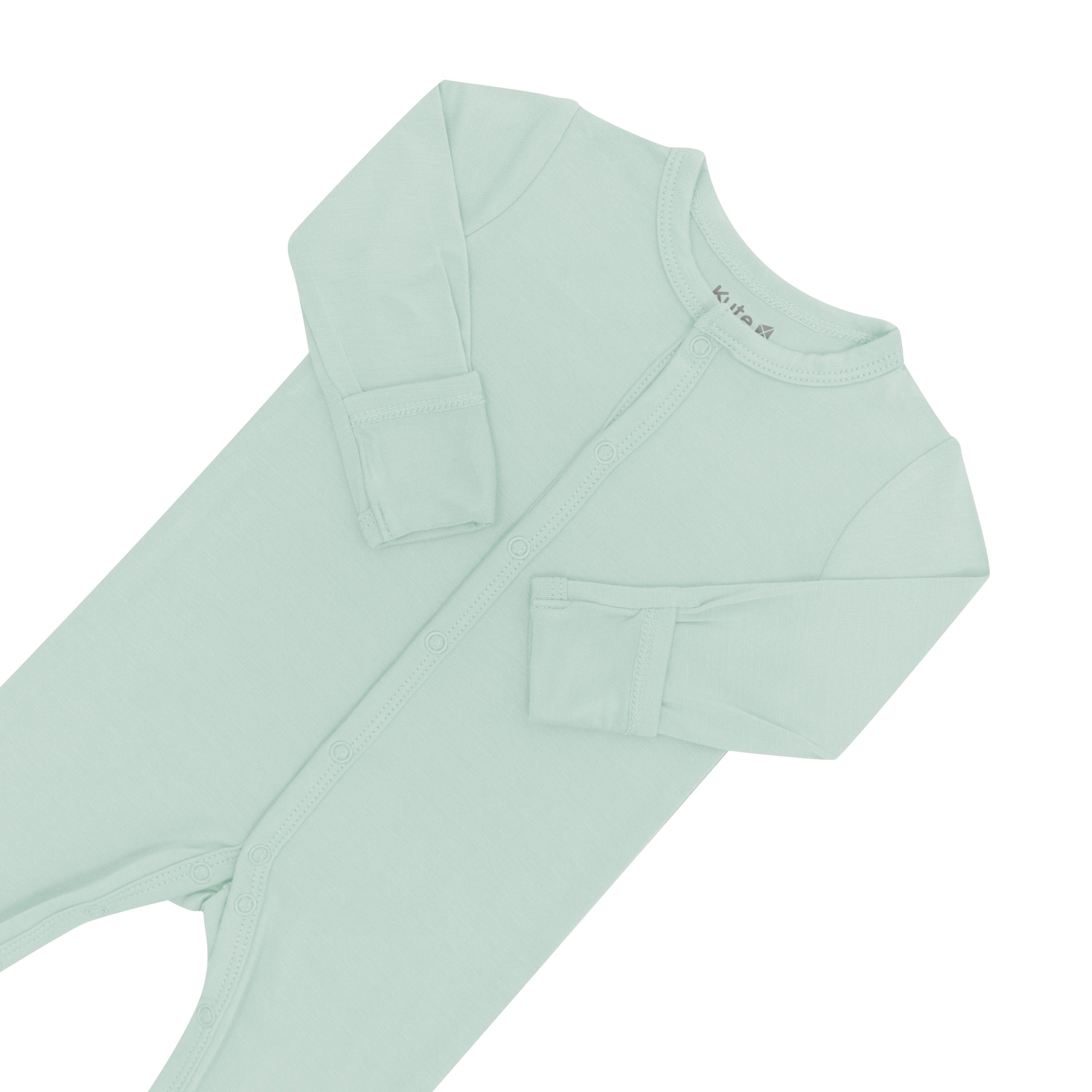 Close up of top portion of Kyte Baby Romper in Sage with arms folded in 