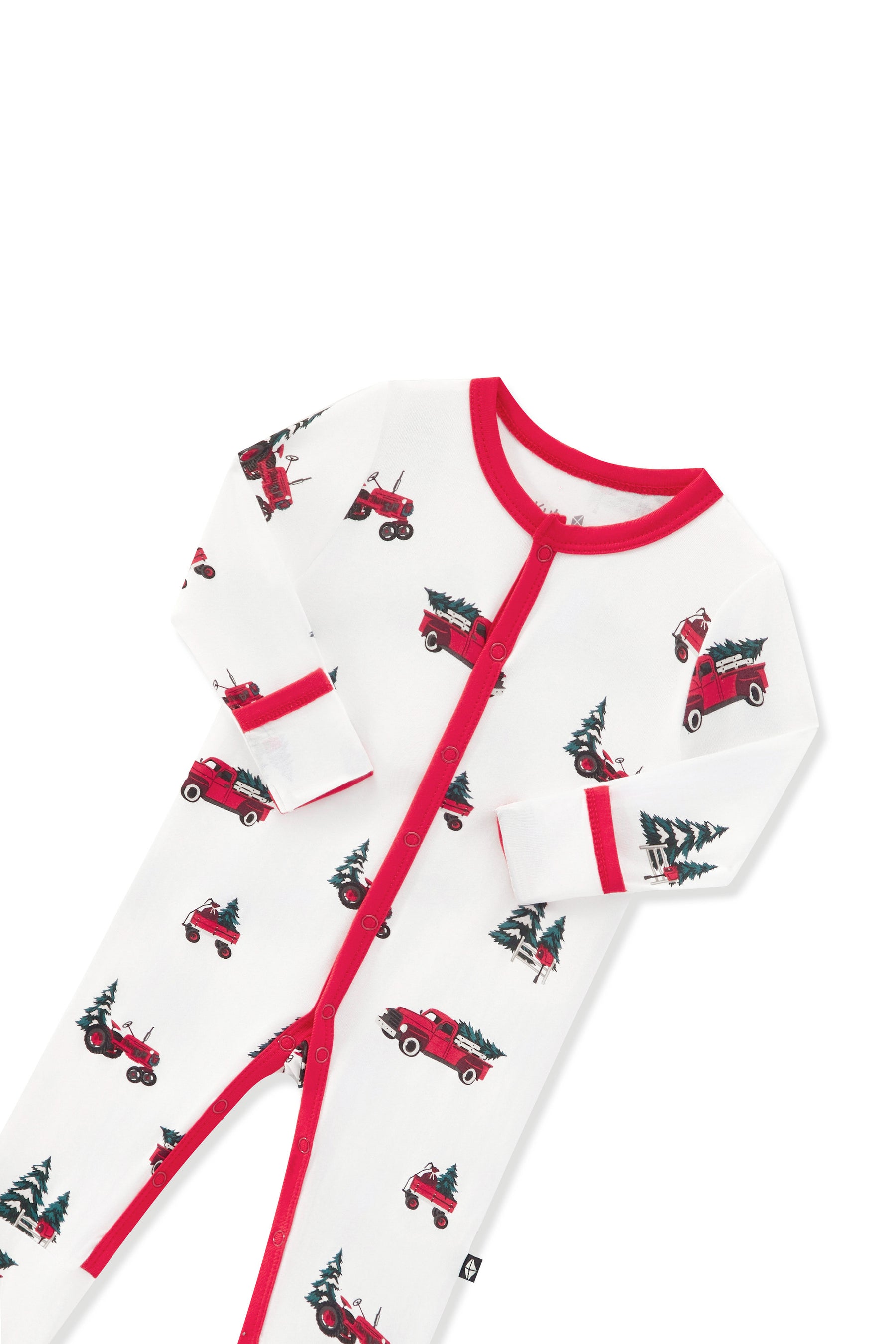 A white long-sleeve baby footless one-piece pajama with red trim and an all-over print of red trucks carrying Christmas trees, shown on a plain white background.