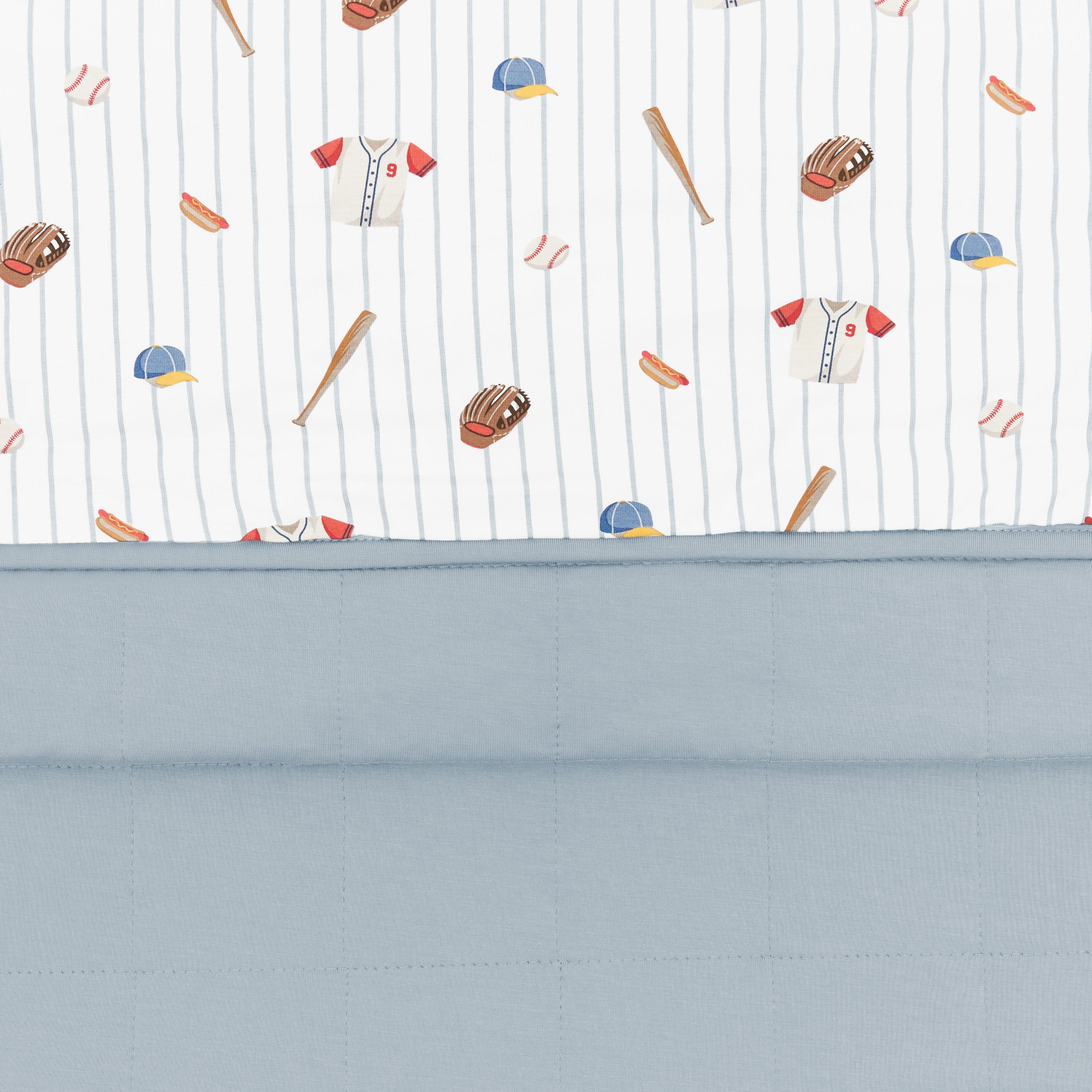 Close up of the Toddler Blanket in Home Run 1.0 showing the muted blue quilted backing and baseball print smooth top layer