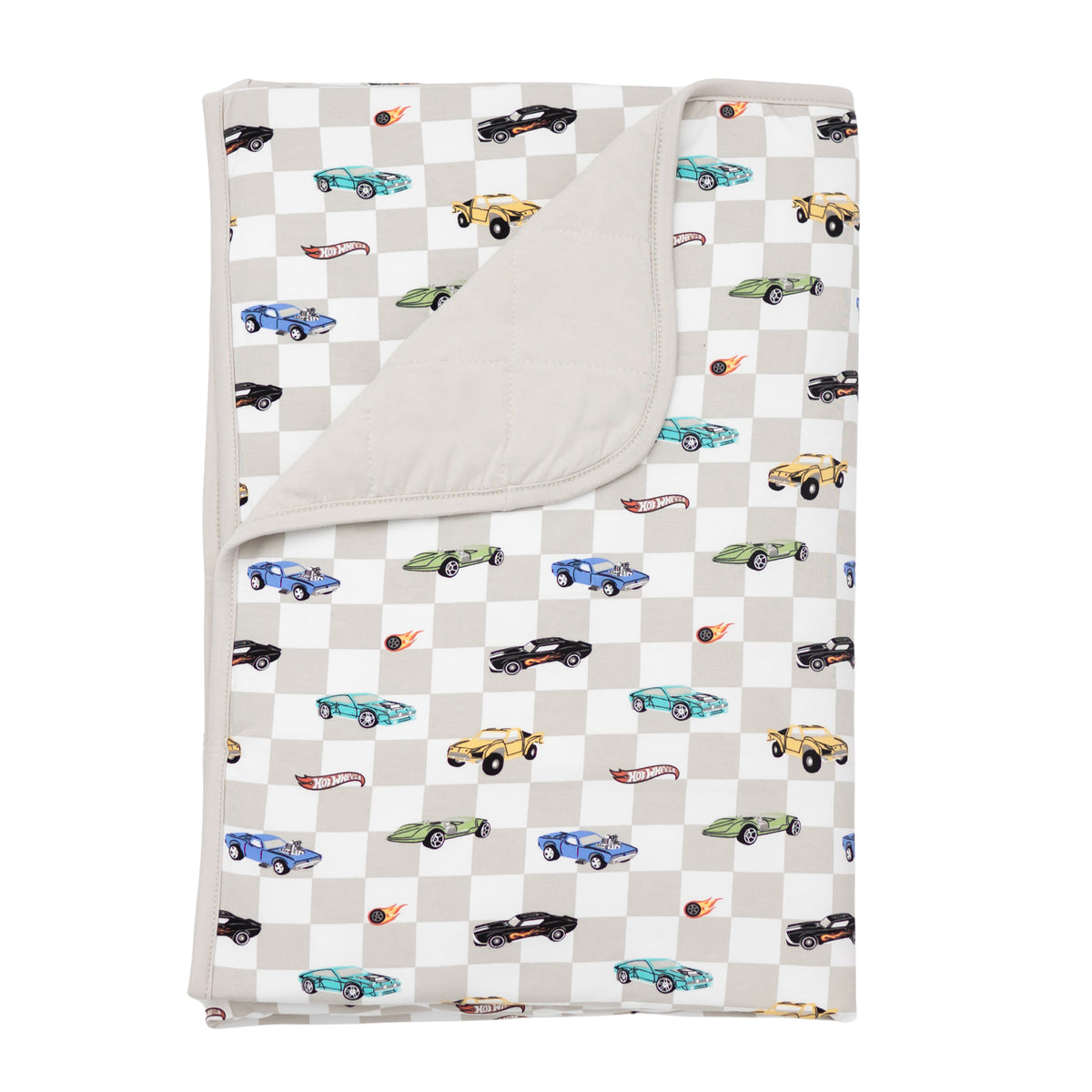 Kyte Baby's Toddler Blanket in Fast and Fierce 1.0 with corner flipped down showing the Oat colored backing