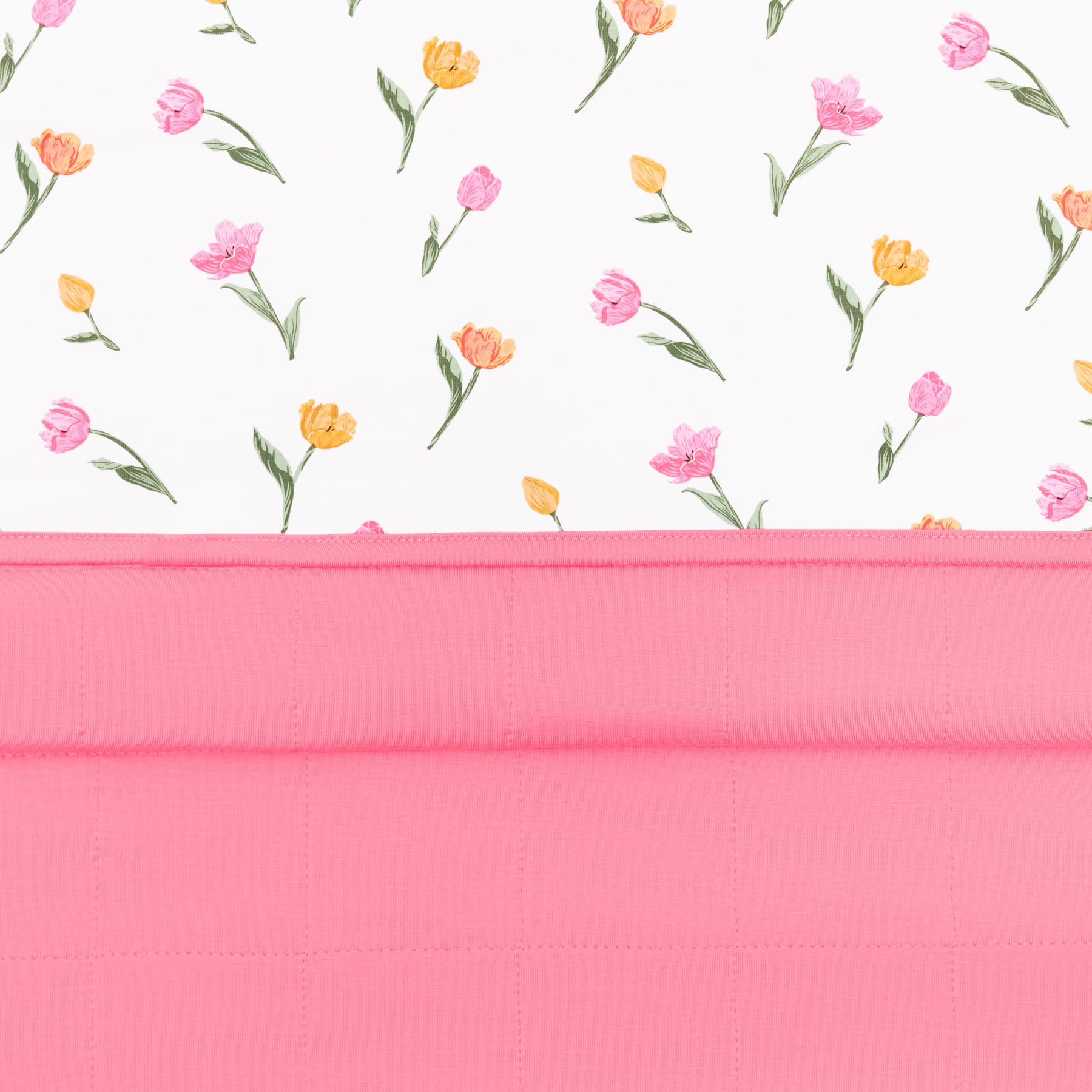 Close up of the Toddler Blanket in Tulip 1.0 showing the quilted pink backing and top floral smooth top layer