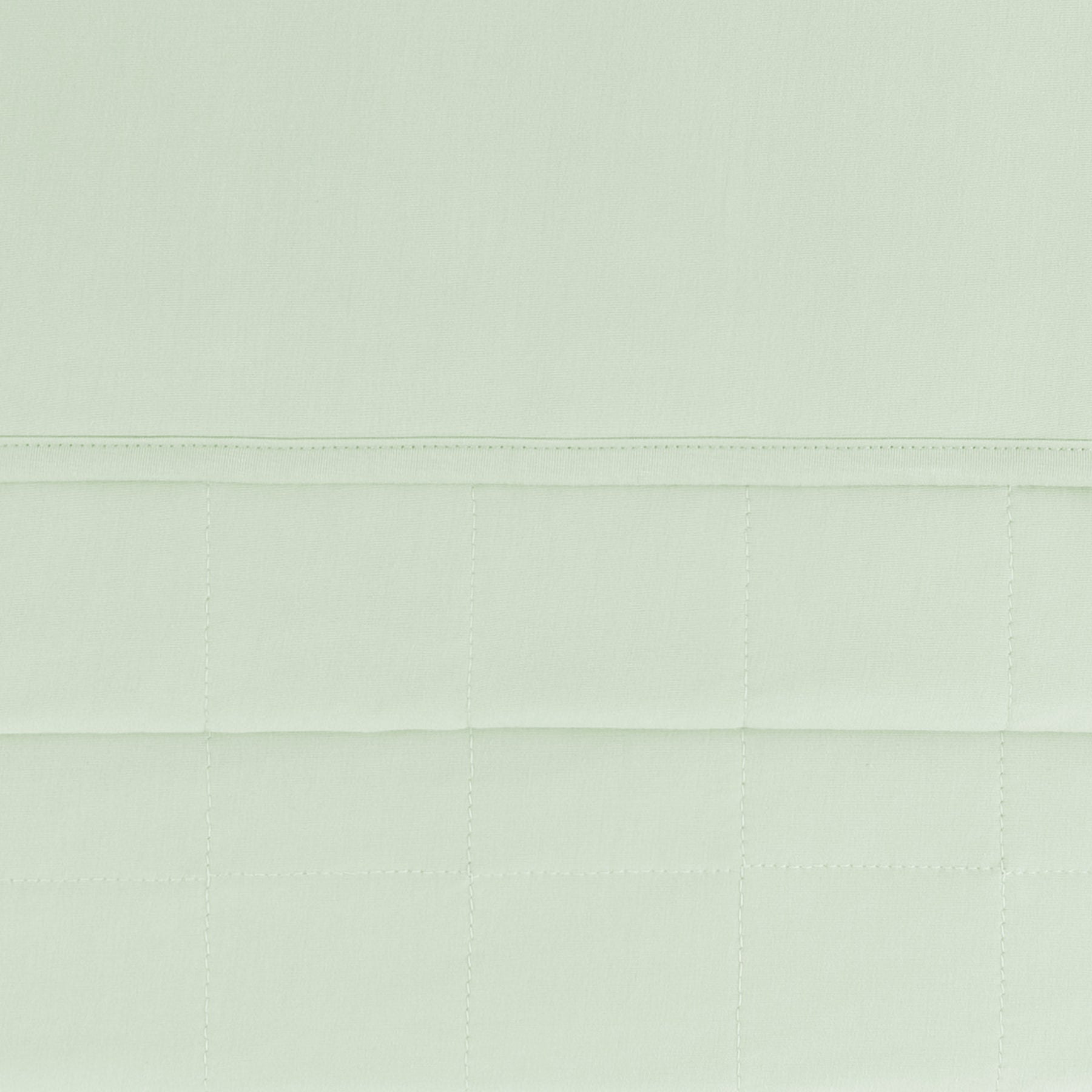 close up of the quilted backing and smooth top layer of the Toddler Blanket in Basil 1.0