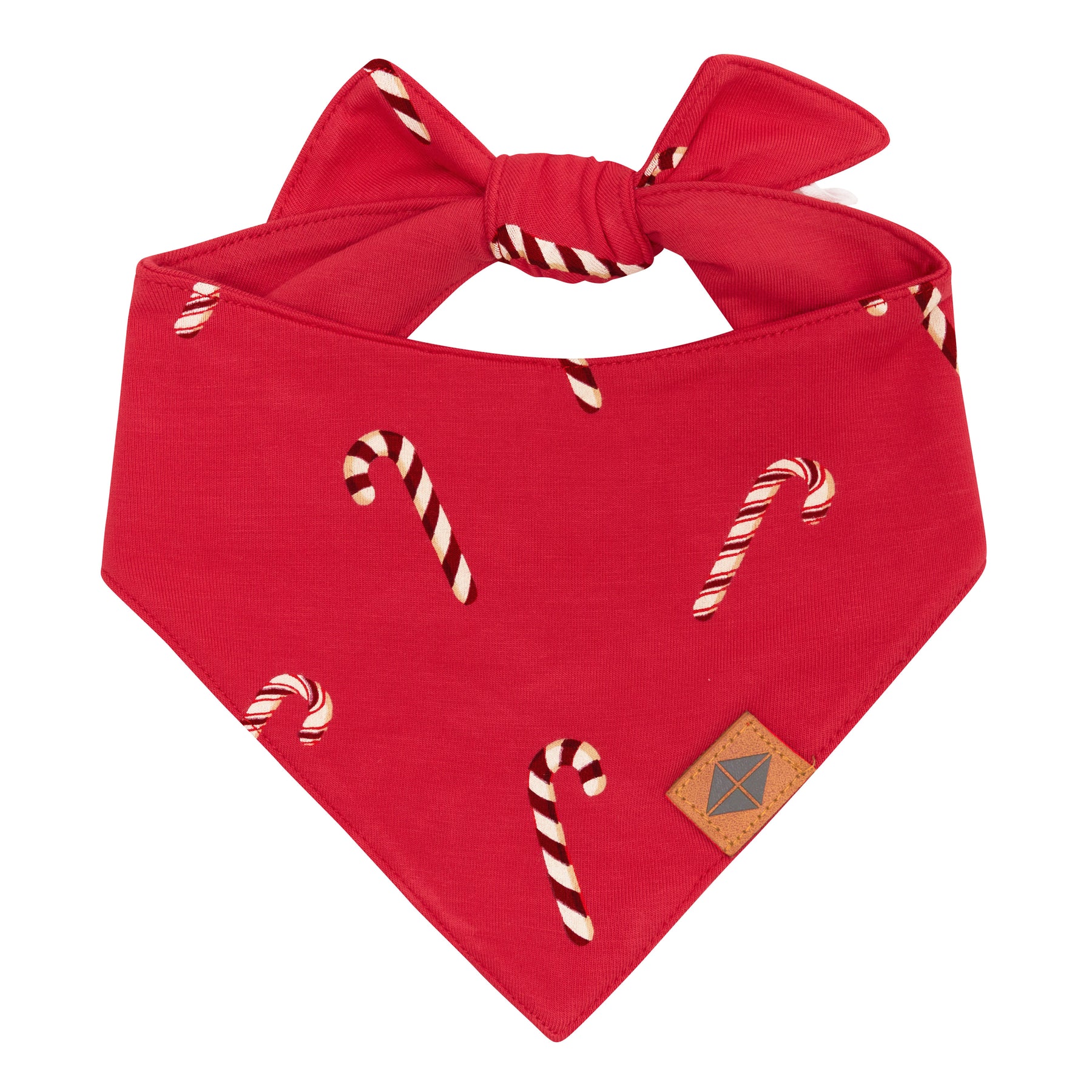 The front of the Dog Bandana in Candy Cane showing the vegan leather tag with the Kyte Baby logo