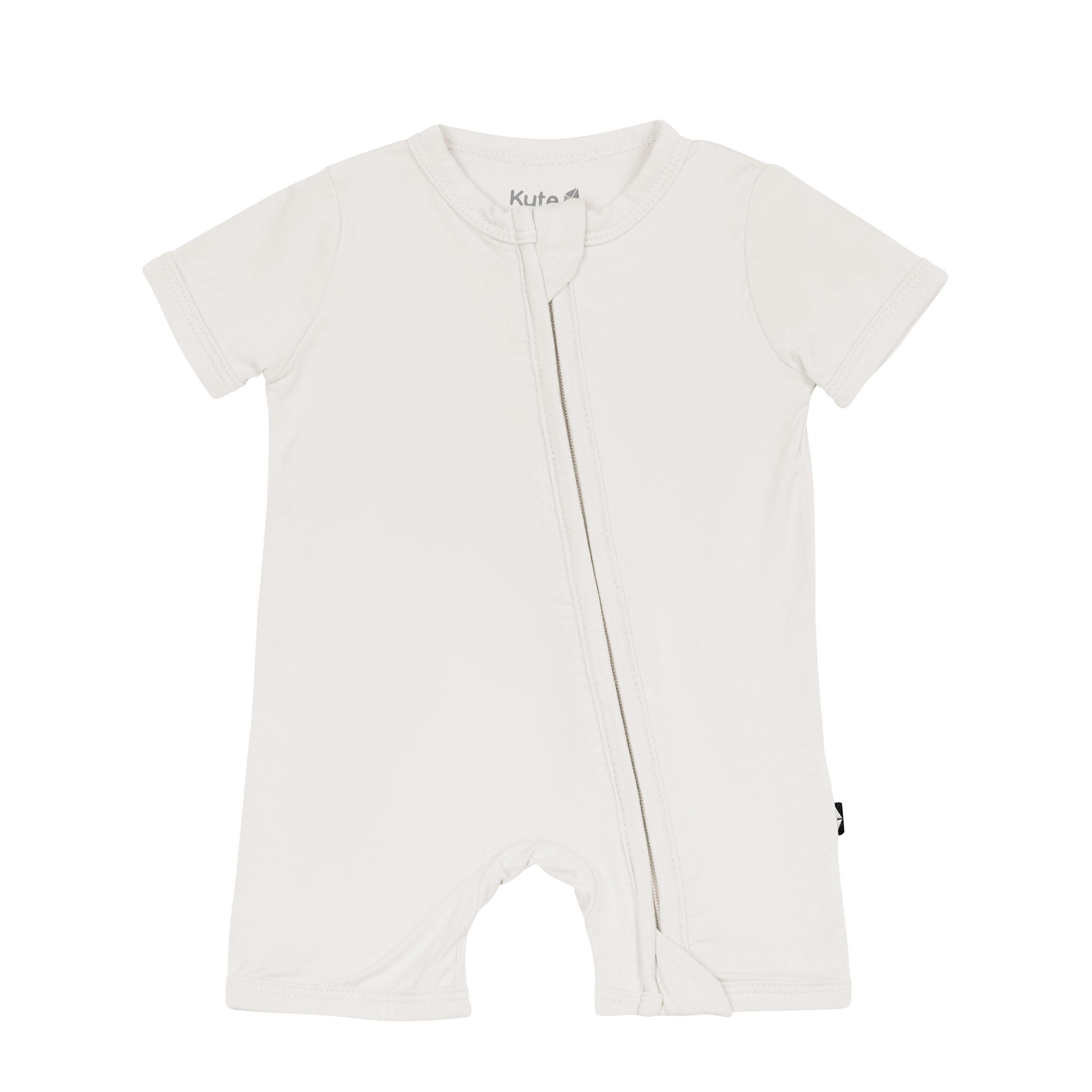 Flat lay of Kyte Baby Zippered Shortall Romper in Oat