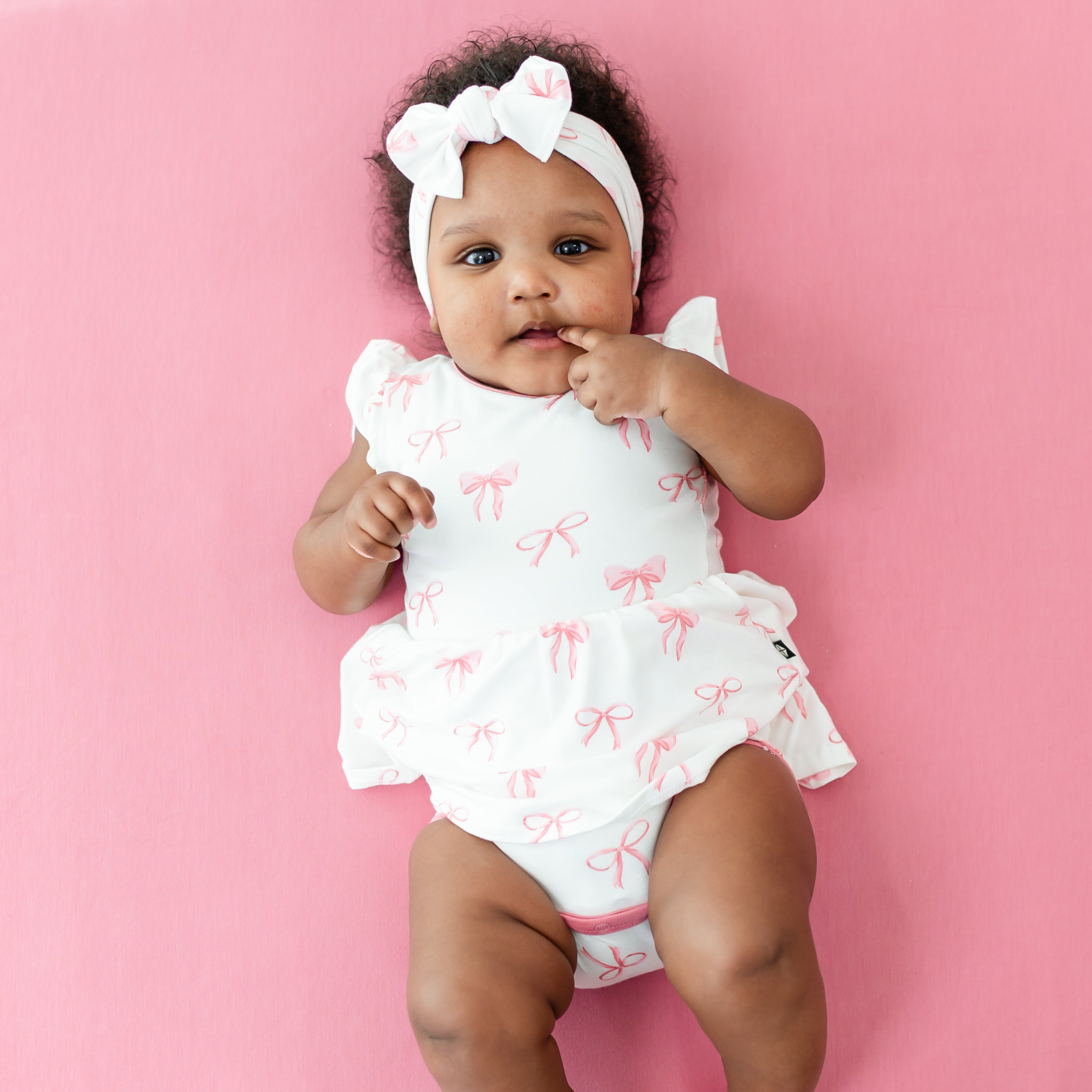 Baby wearing Twirl Bodysuit Dress in Bow with matching headband