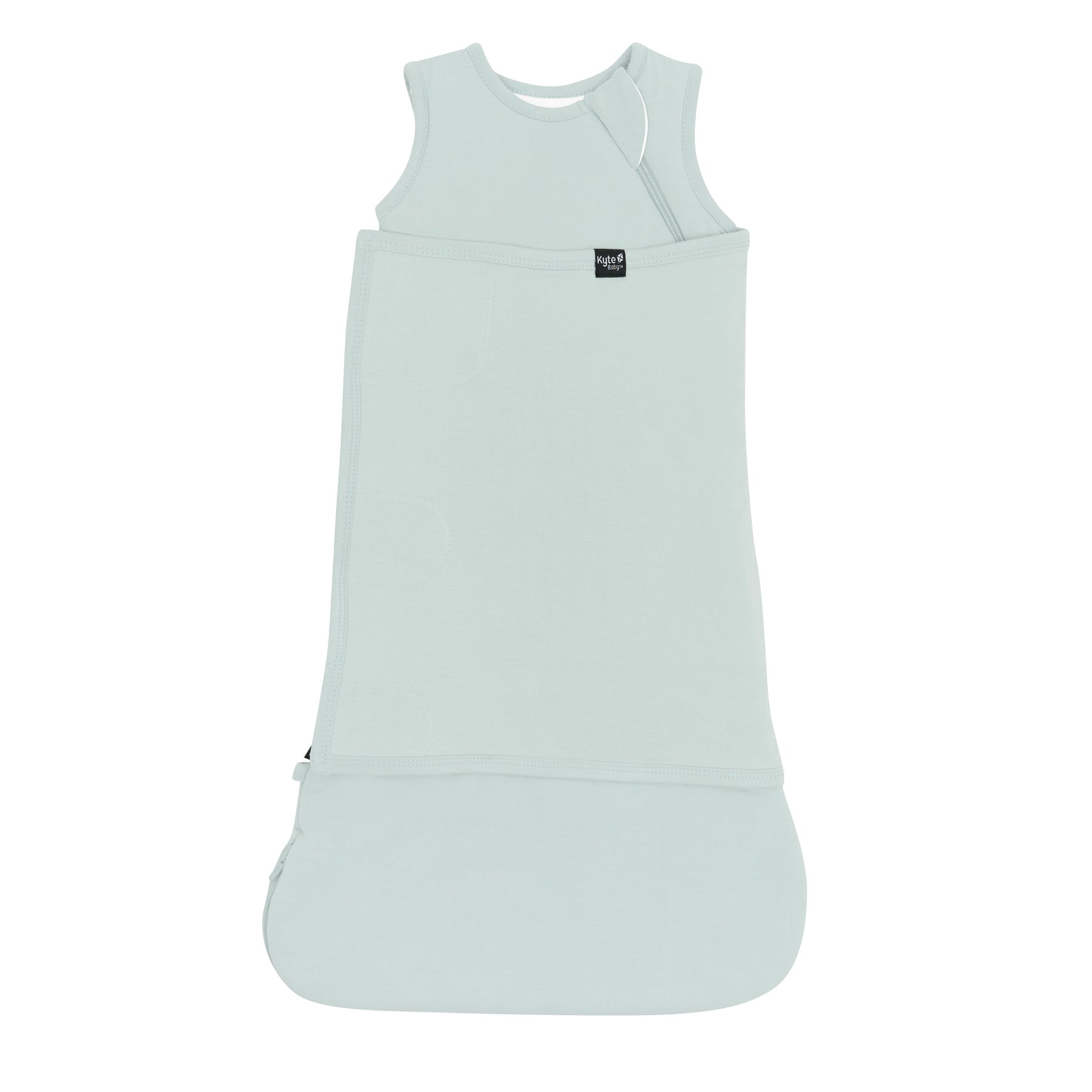 Sleep Bag Swaddler in Sage 1.0 shown swaddled with the Black Kyte Baby logo visible